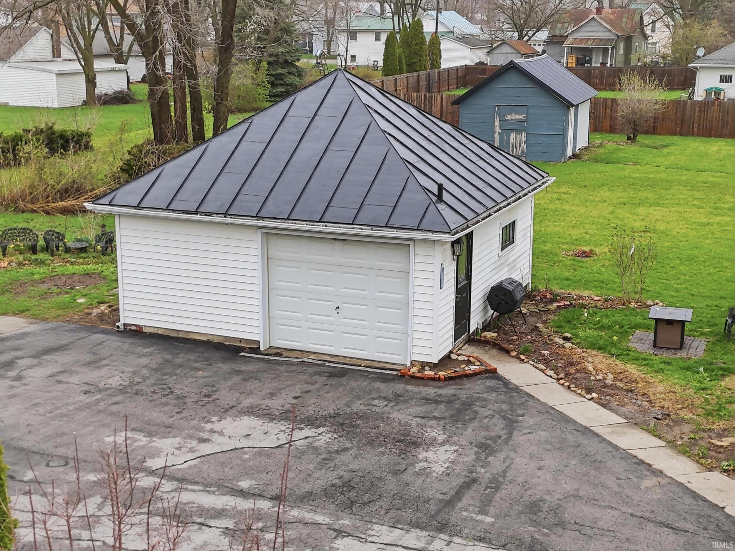 Detached garage with a residential view and asphalt driveway