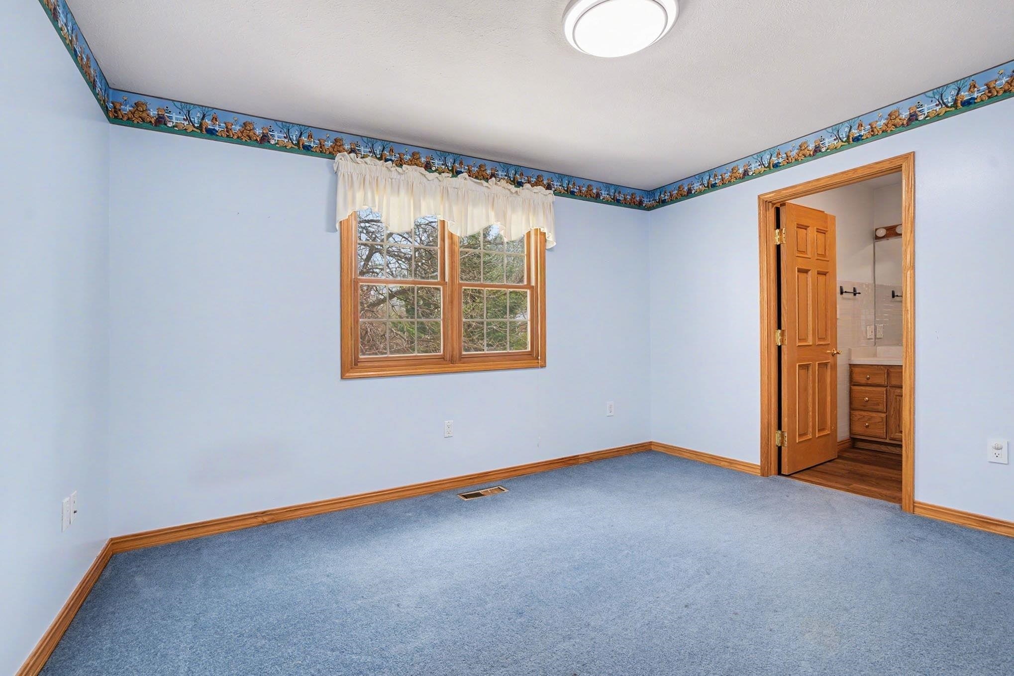 Unfurnished bedroom with carpet and connected bathroom