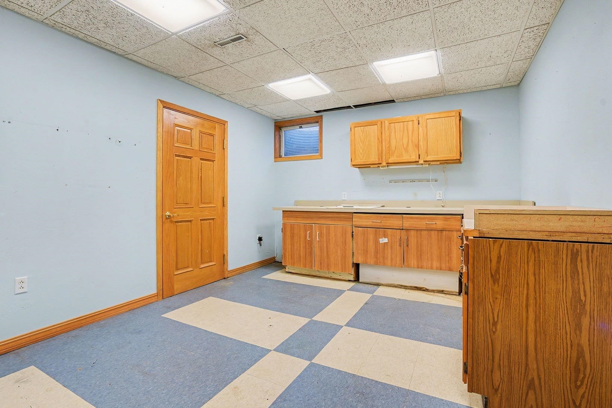 Kitchen featuring light flooring, light countertops, and a paneled ceiling