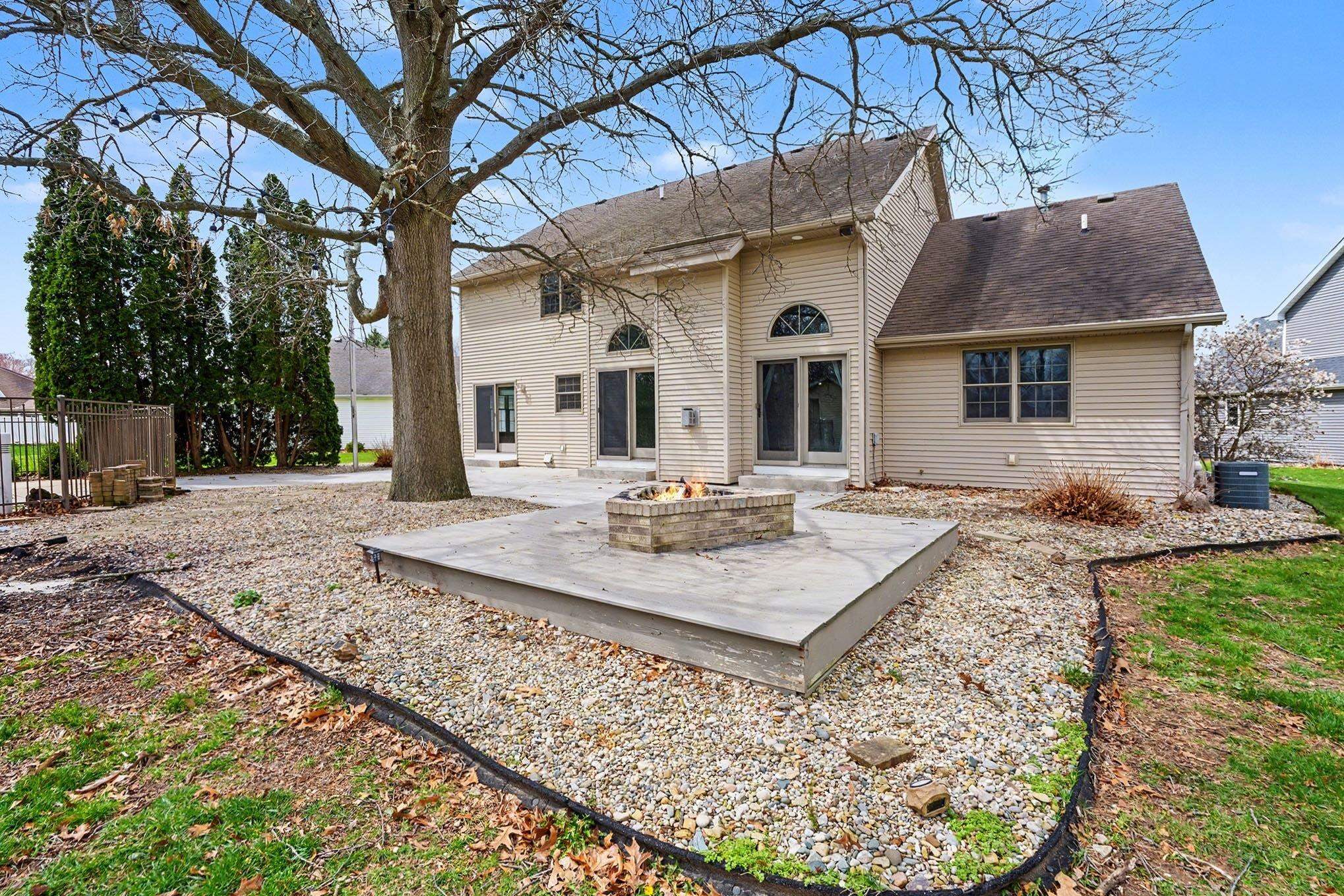 Back of house with a fire pit, a patio, and a shingled roof