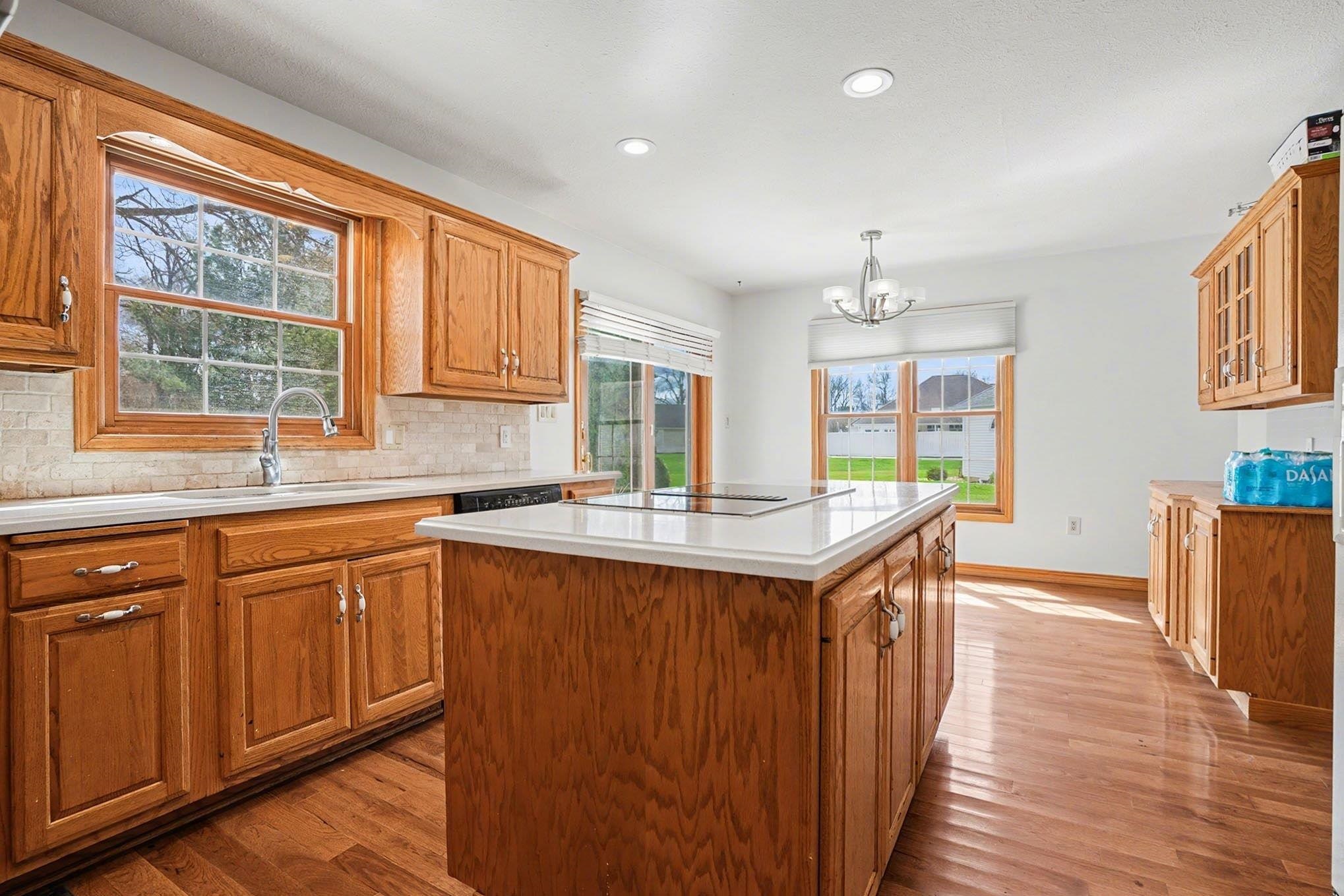 Kitchen featuring a center island, light countertops, wood finish cabinets, and light wood-style floors