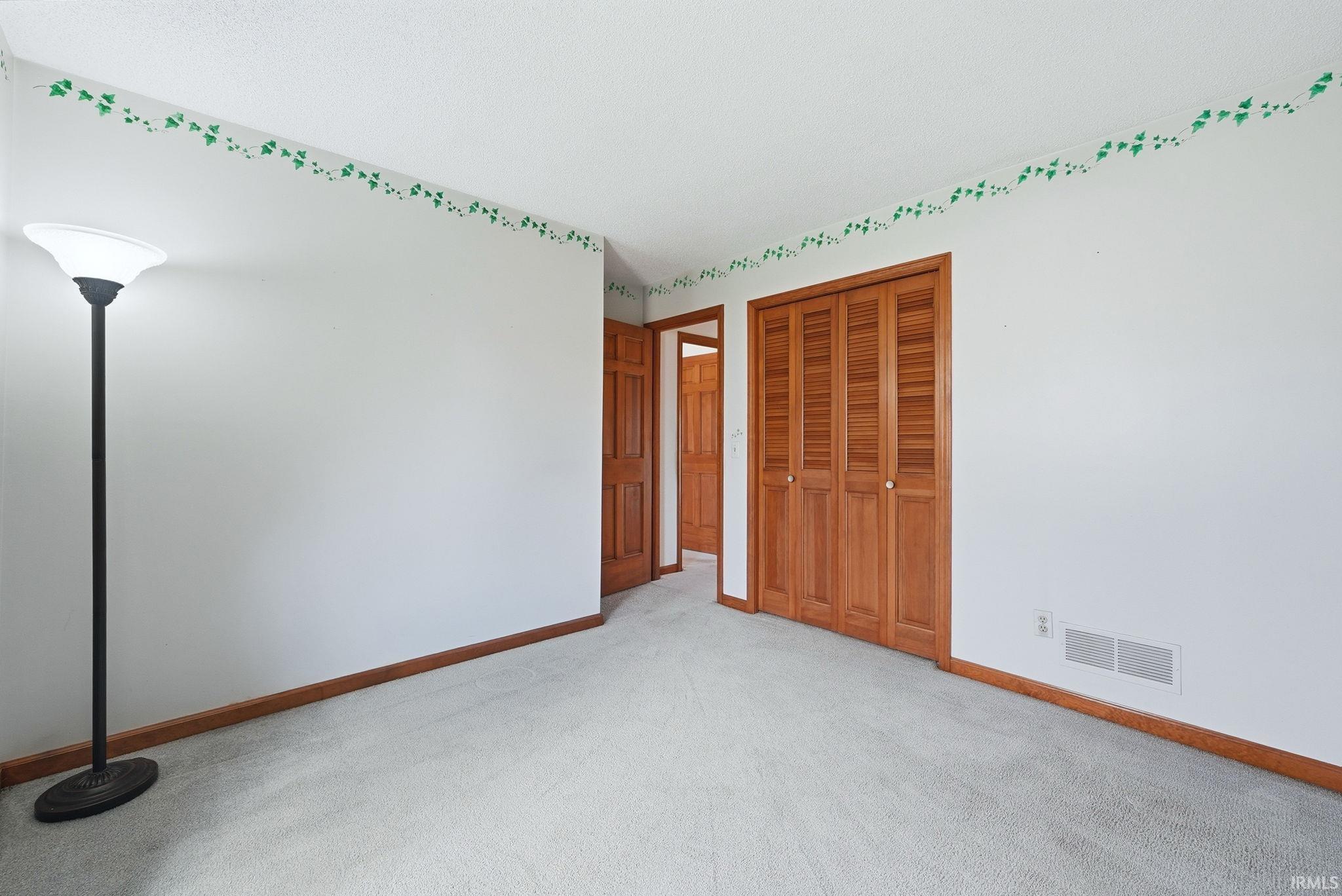 Unfurnished bedroom featuring a closet and light carpet