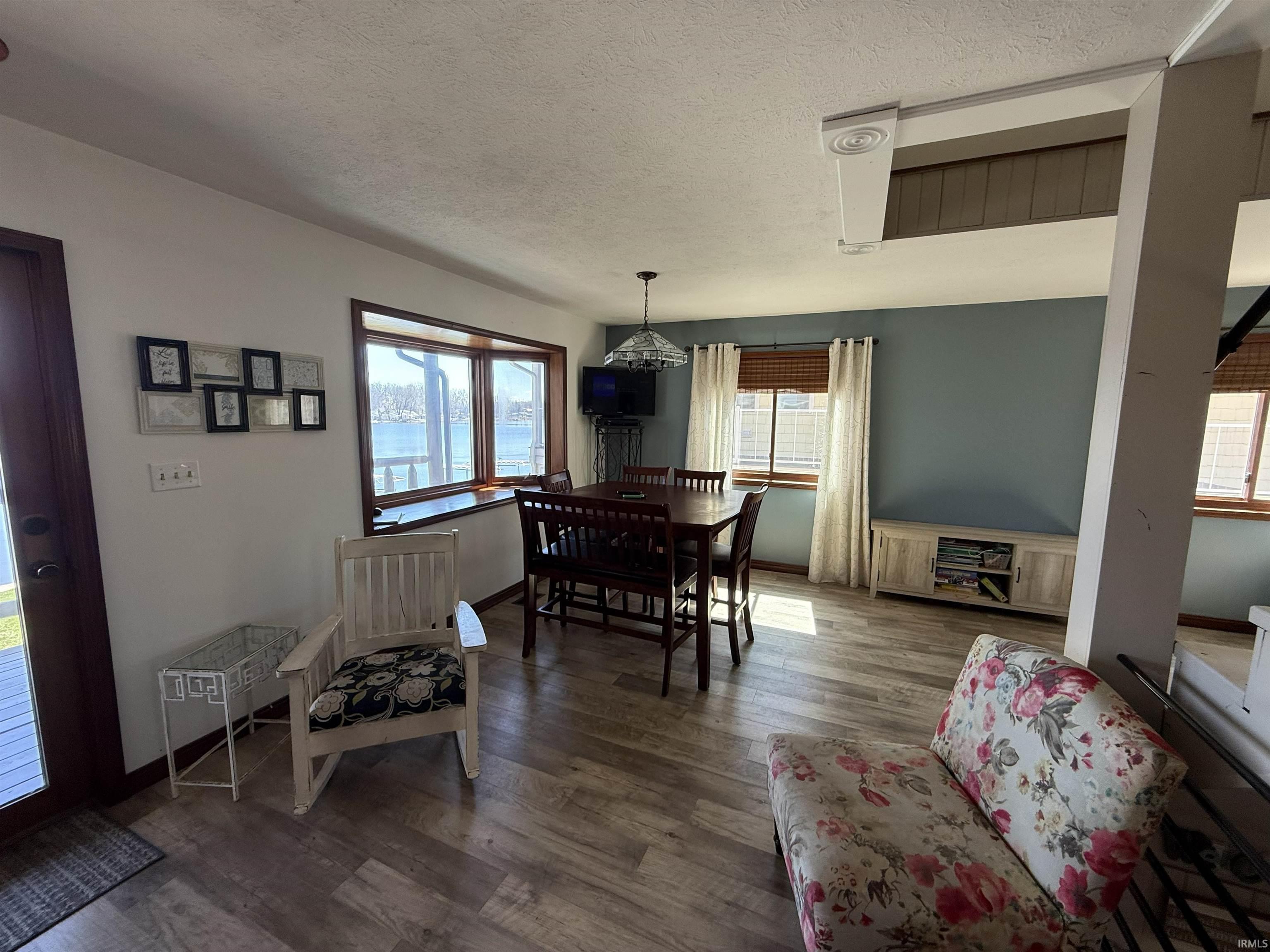 Dining space with dark wood finished floors and a textured ceiling