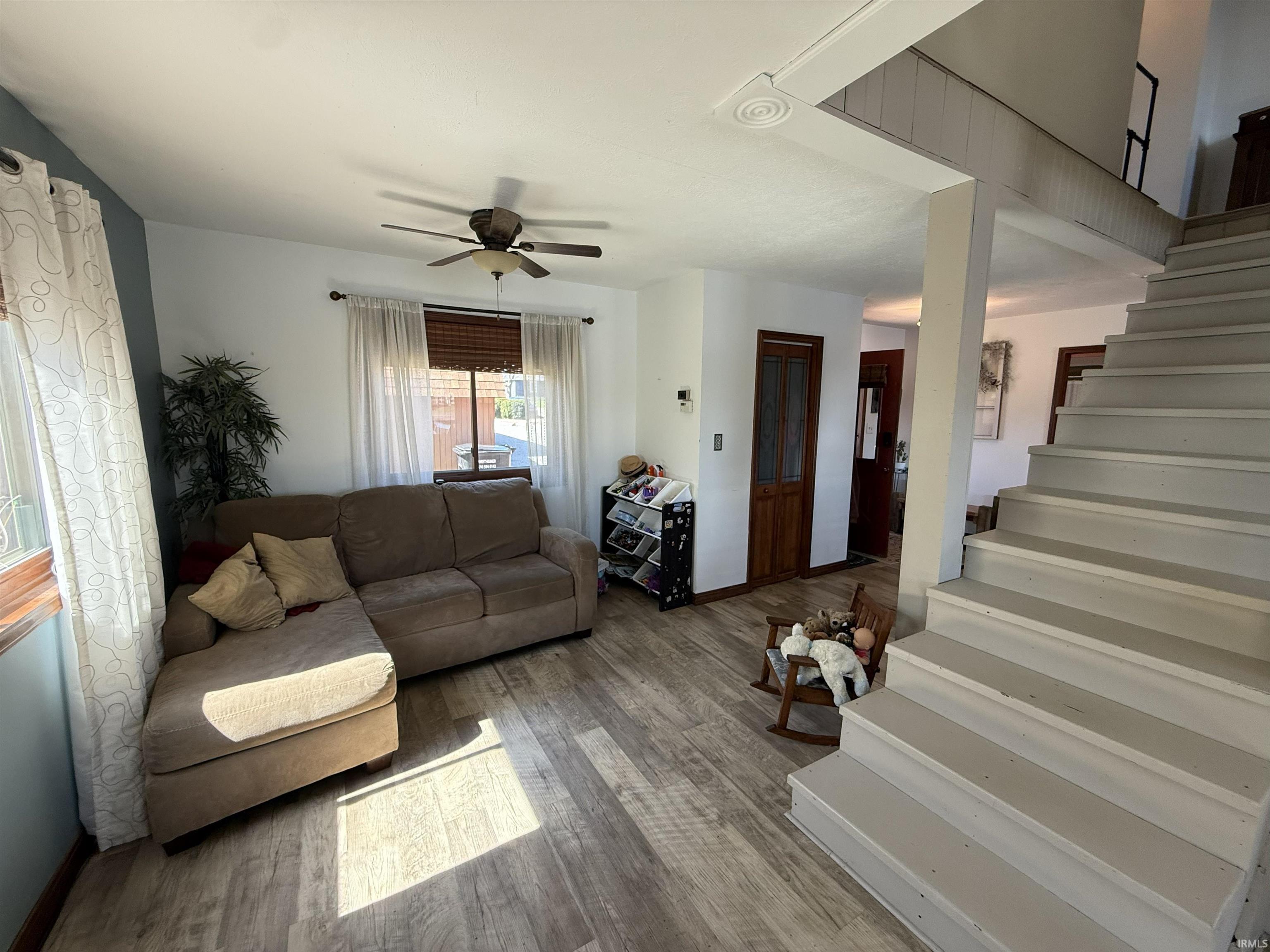 Living area featuring wood finished floors and a ceiling fan