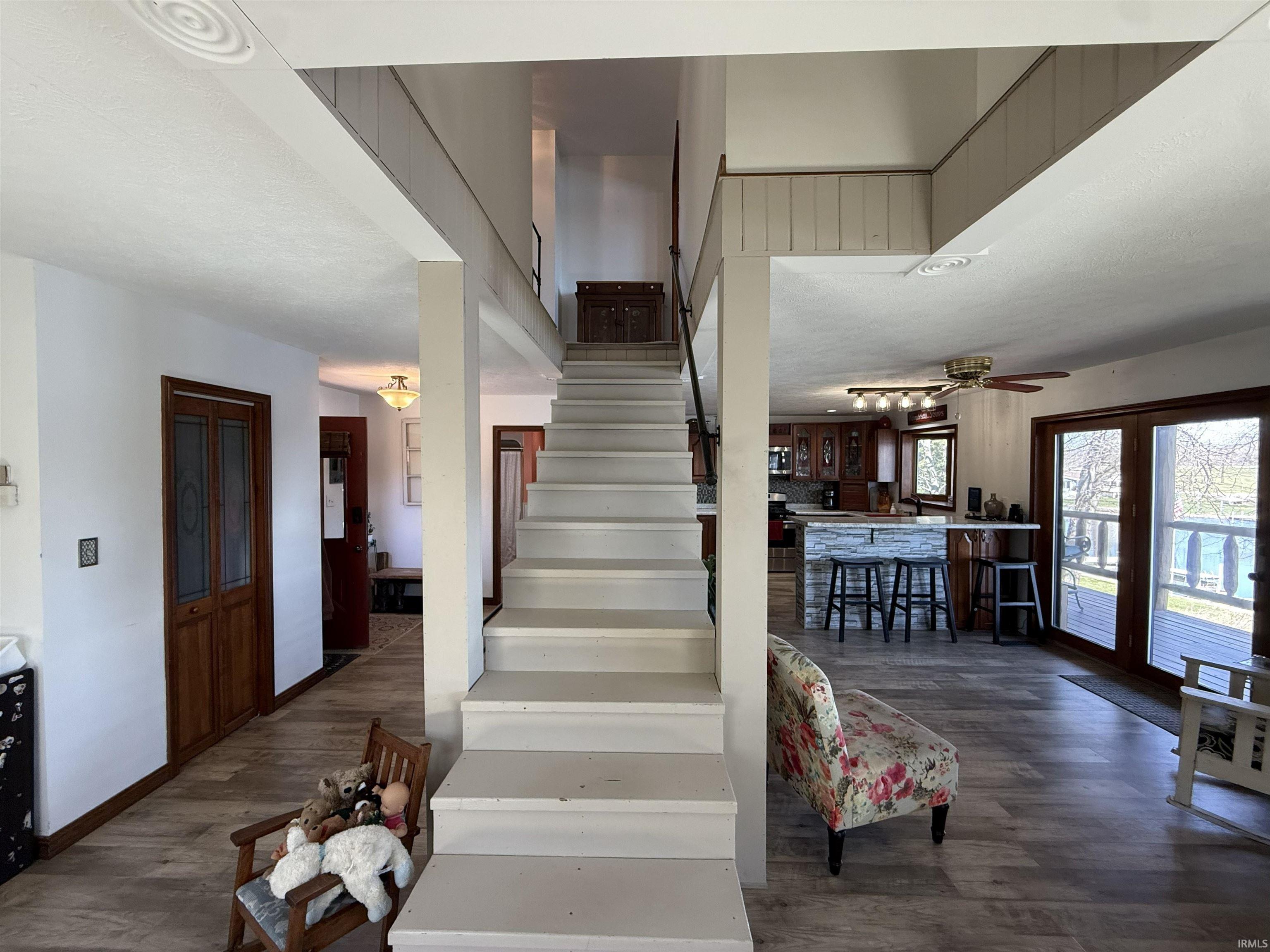 Staircase featuring a ceiling fan and wood finished floors