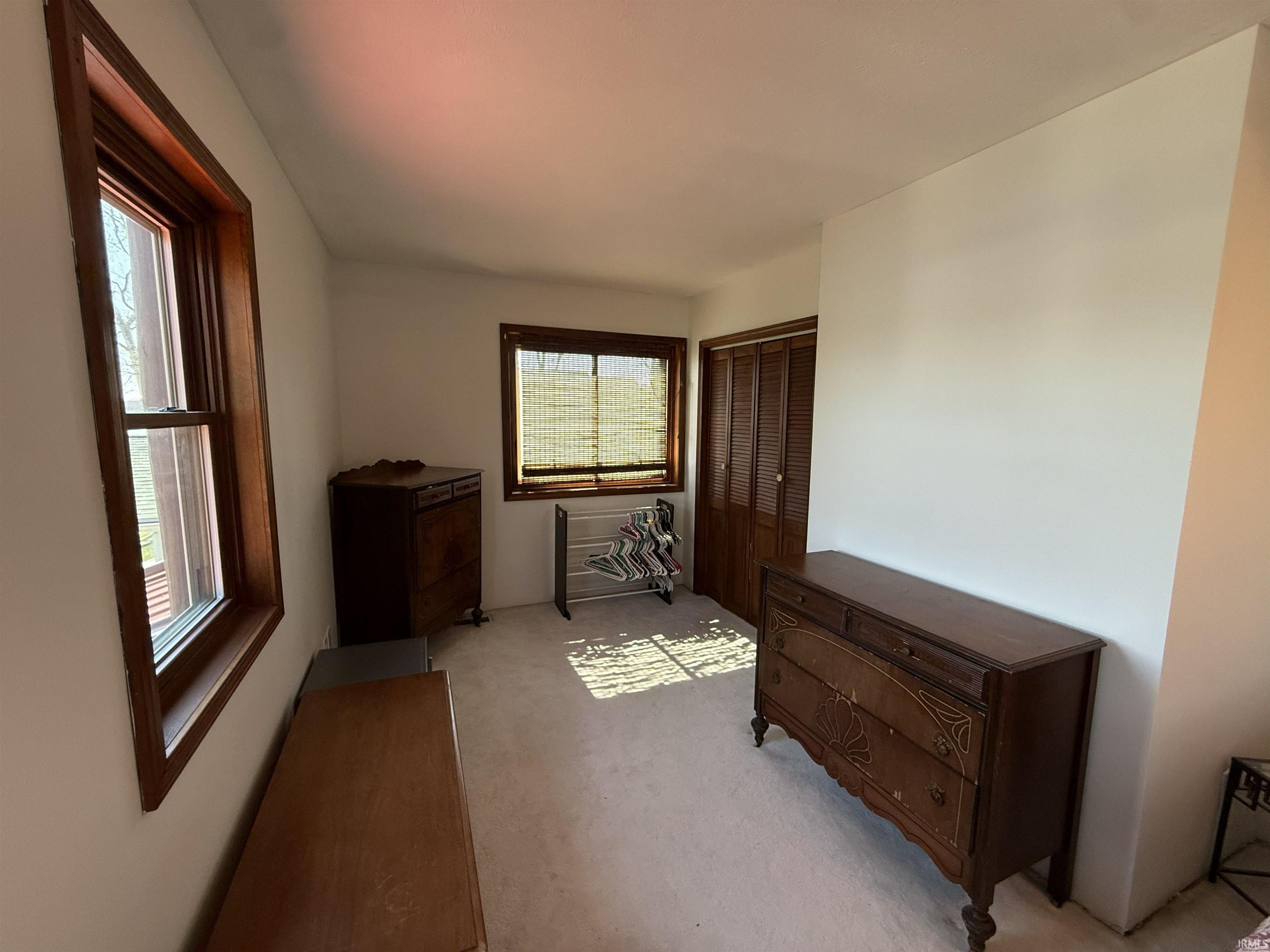 Bedroom featuring light carpet and a closet
