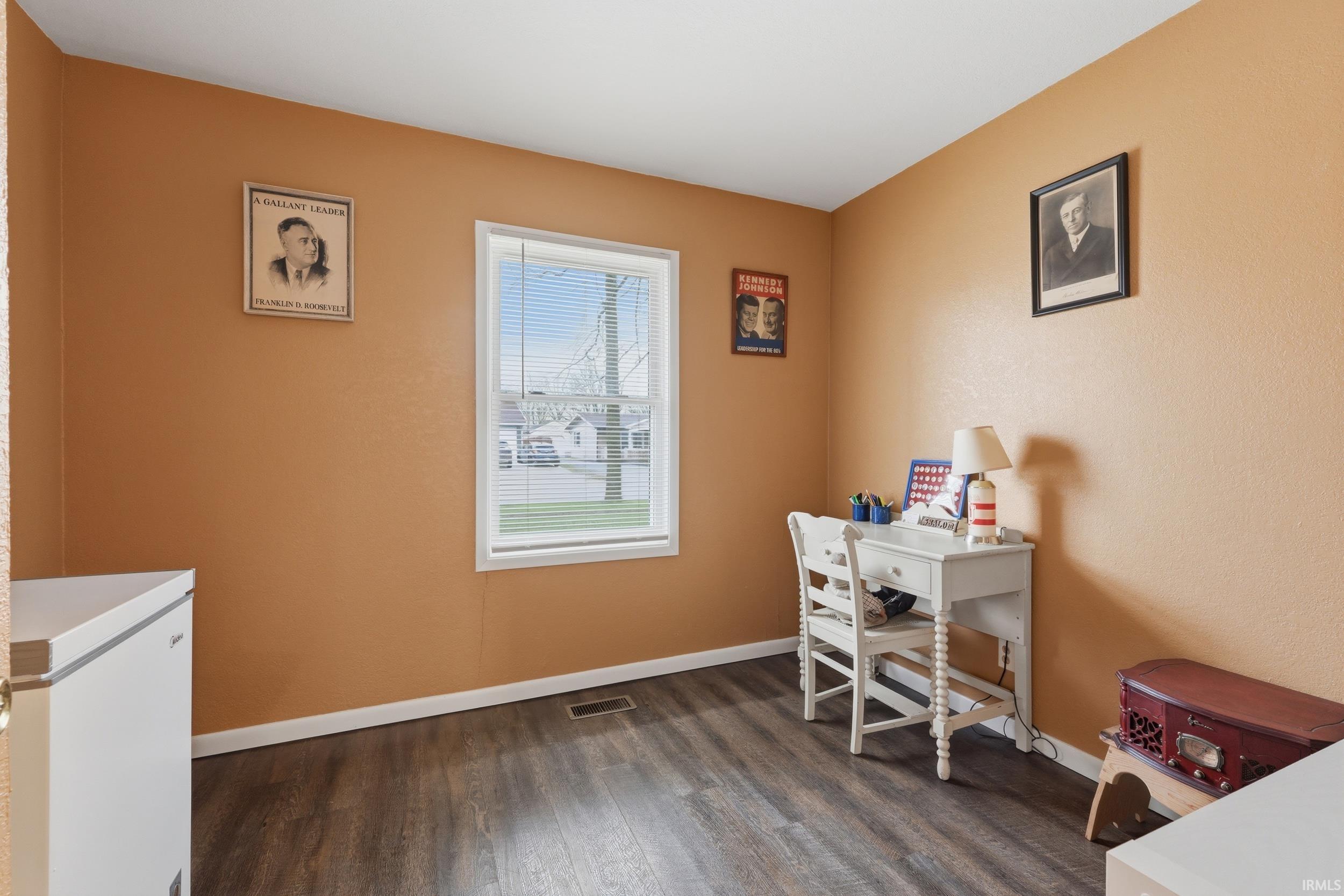 Office space featuring dark wood-style flooring and baseboards