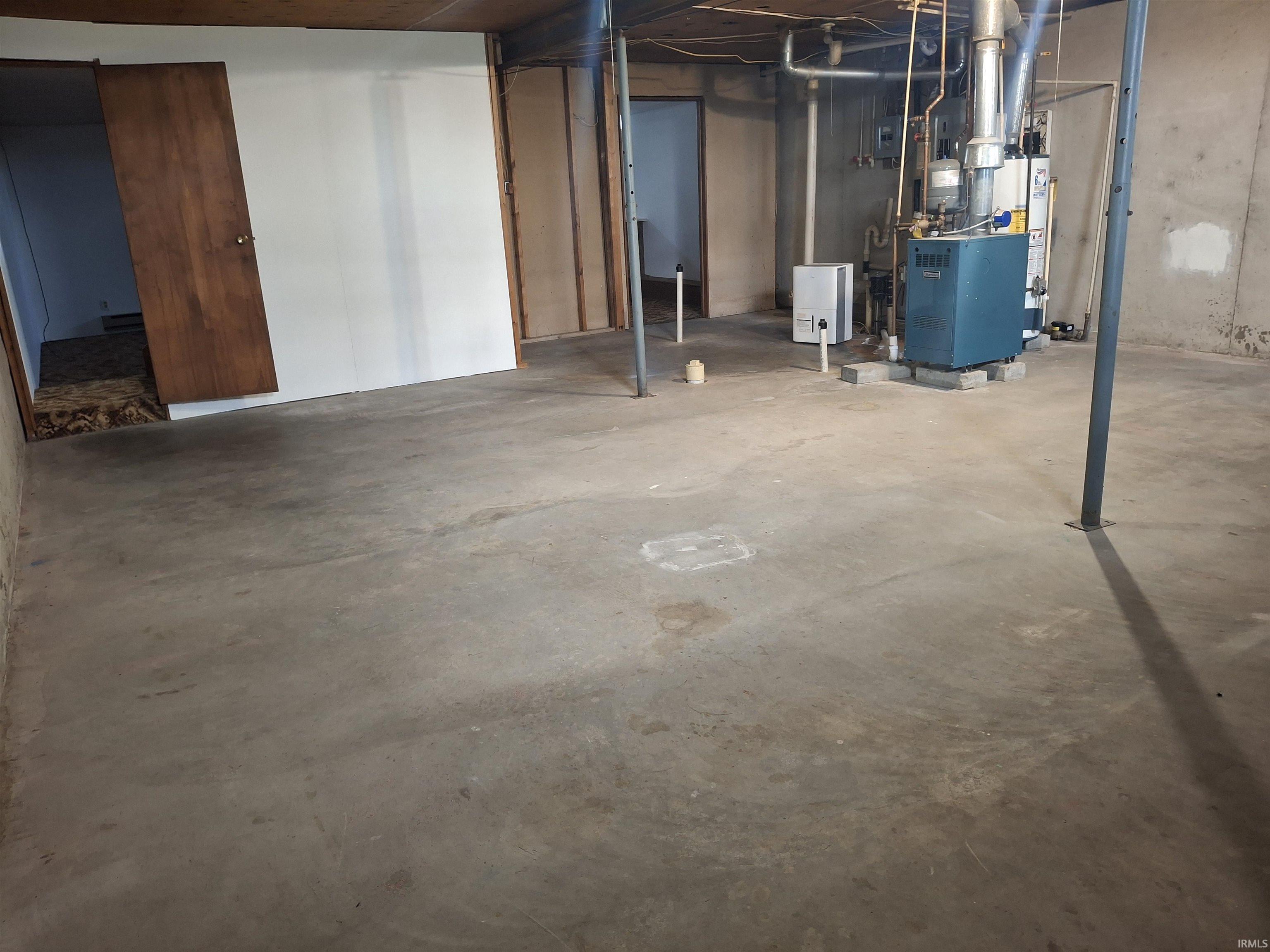 Unfinished below grade area with a heating unit and water heater