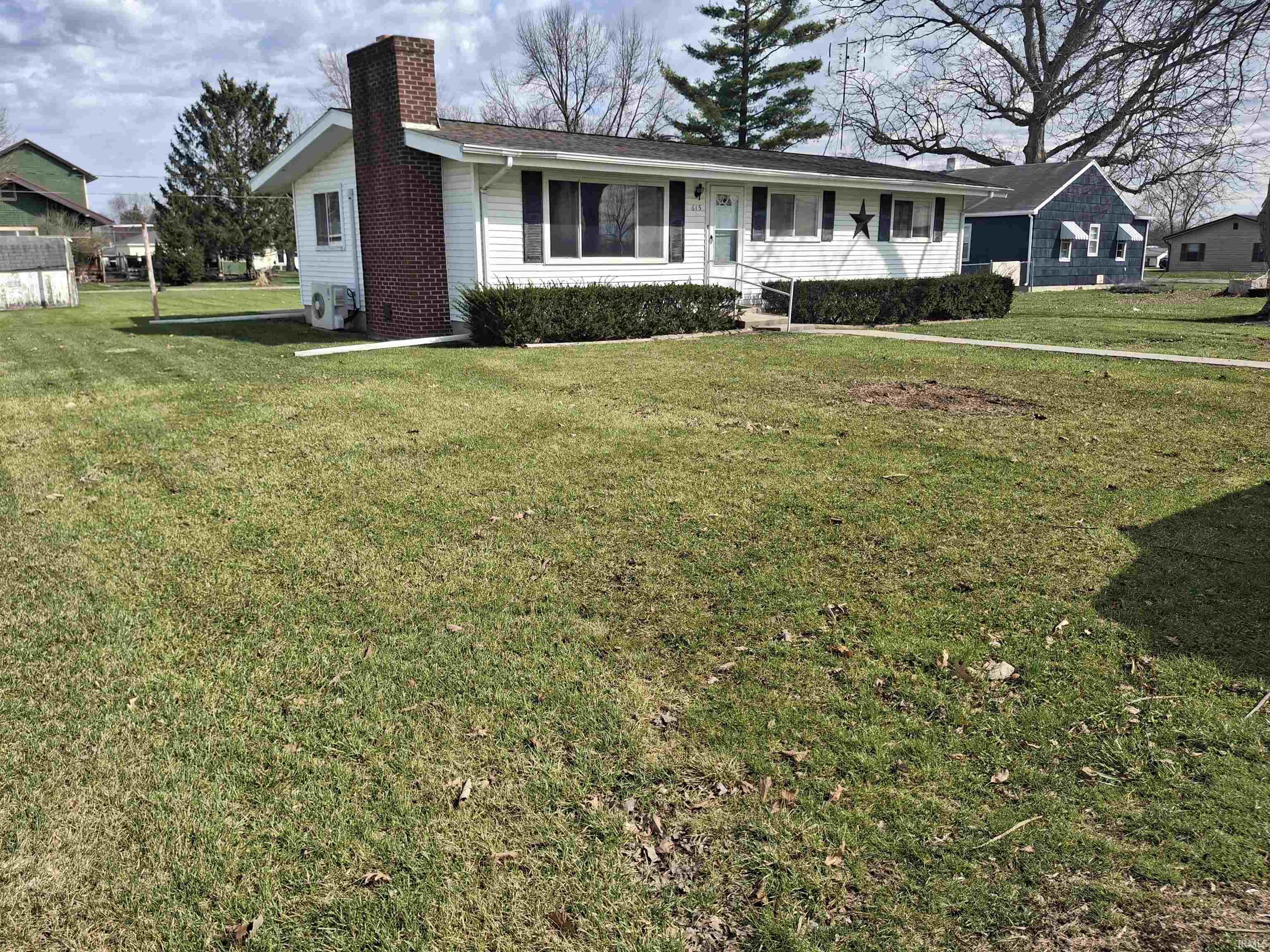 Ranch-style house with a front yard and a chimney
