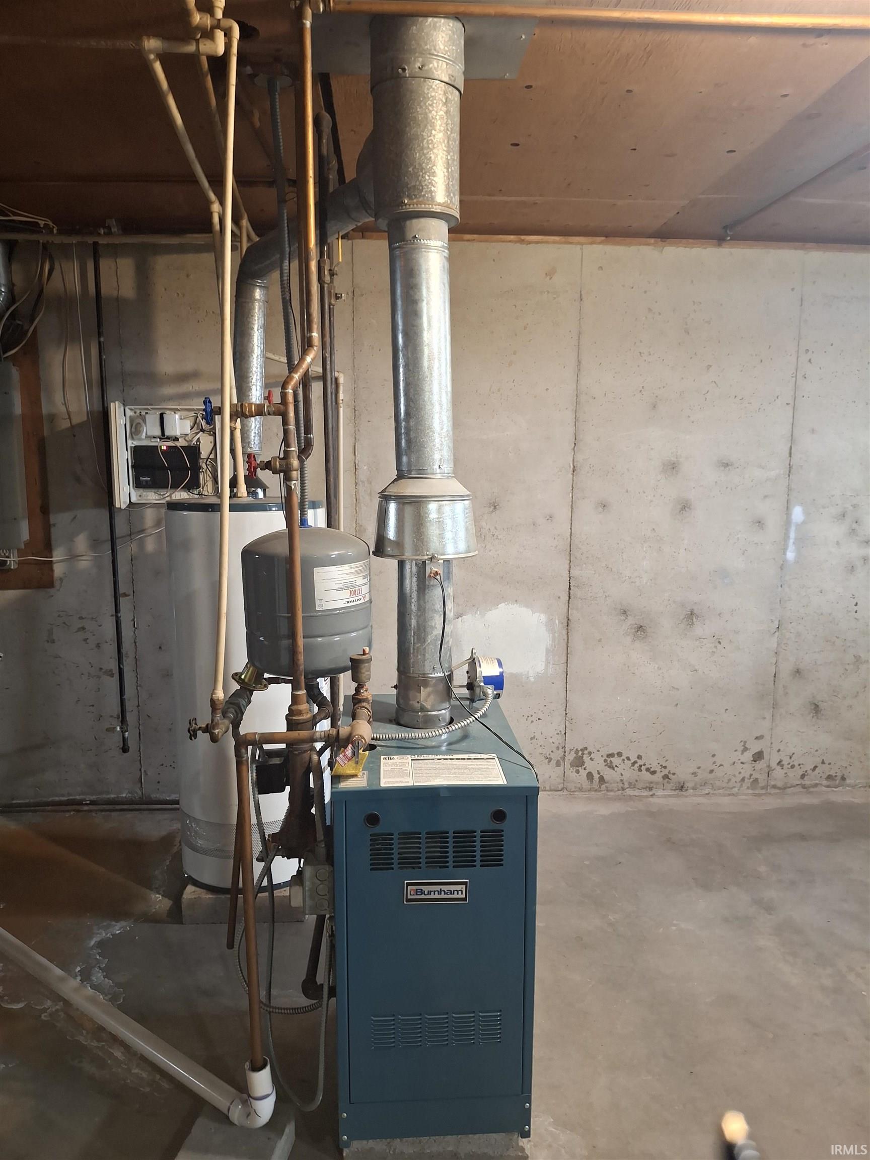 Utility room featuring a heating unit and water heater