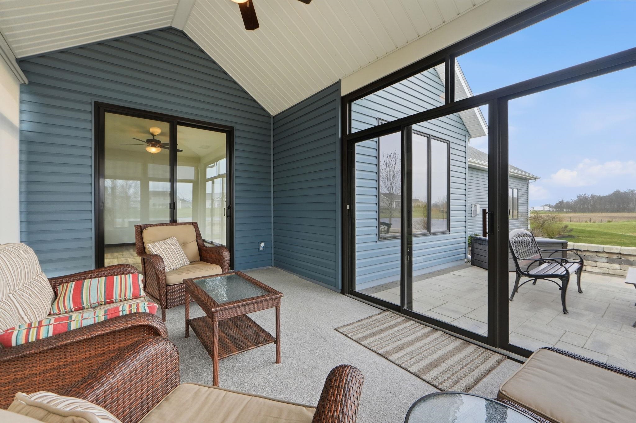Sunroom / solarium with ceiling fan, an outdoor living space, and a patio area