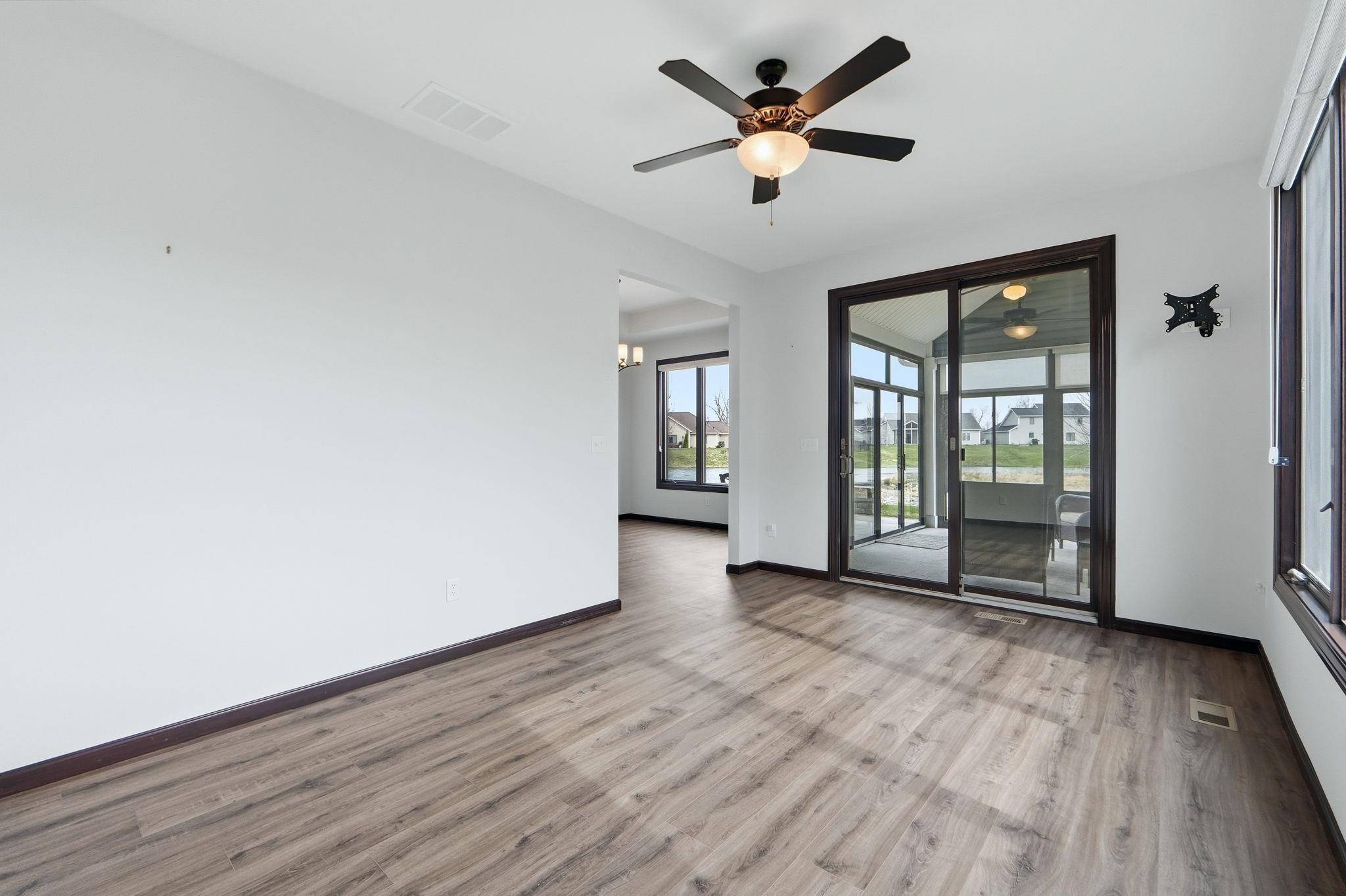 Empty room featuring ceiling fan, light wood-style flooring, and hanging lights