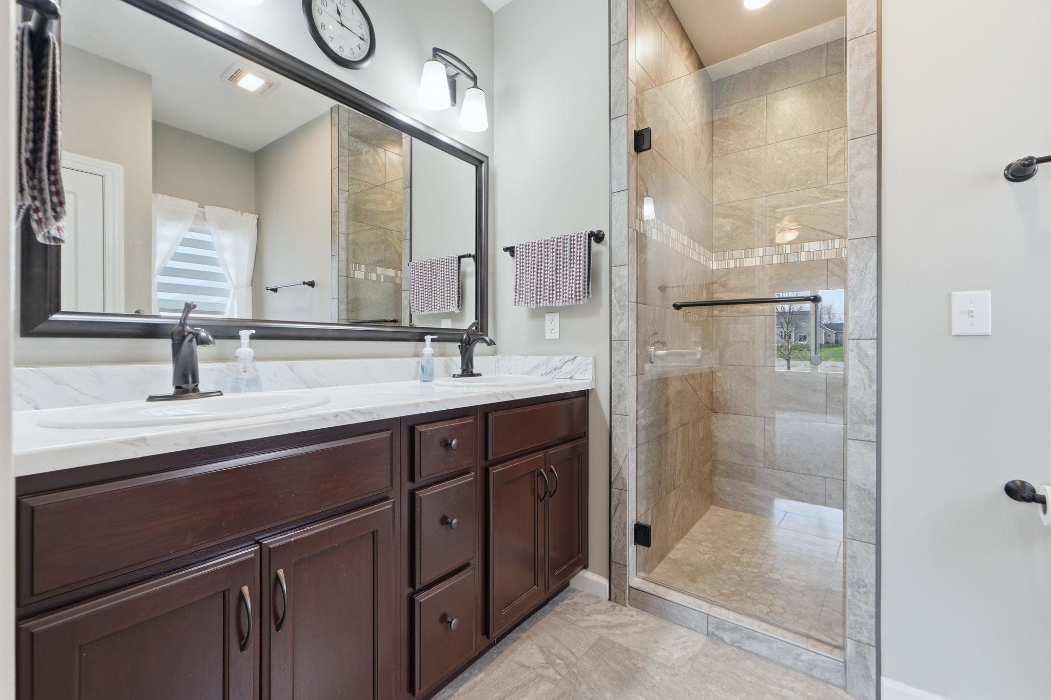 Bathroom with double vanity and a shower stall