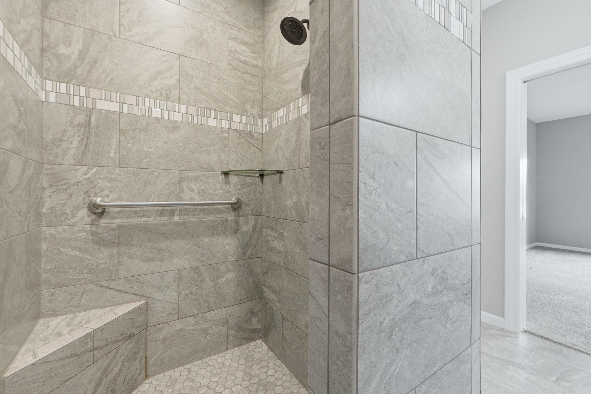Bathroom with a tile shower and baseboards
