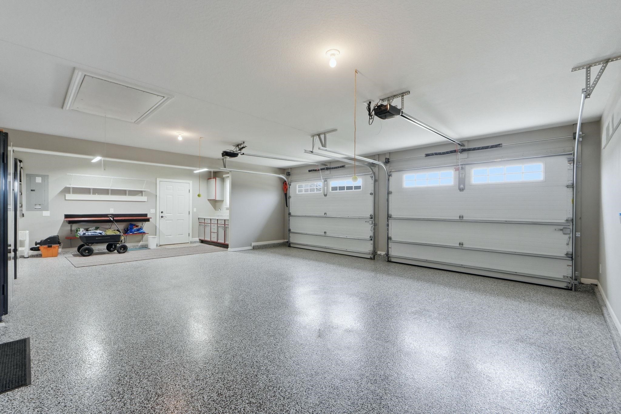 Garage with baseboards and electric panel