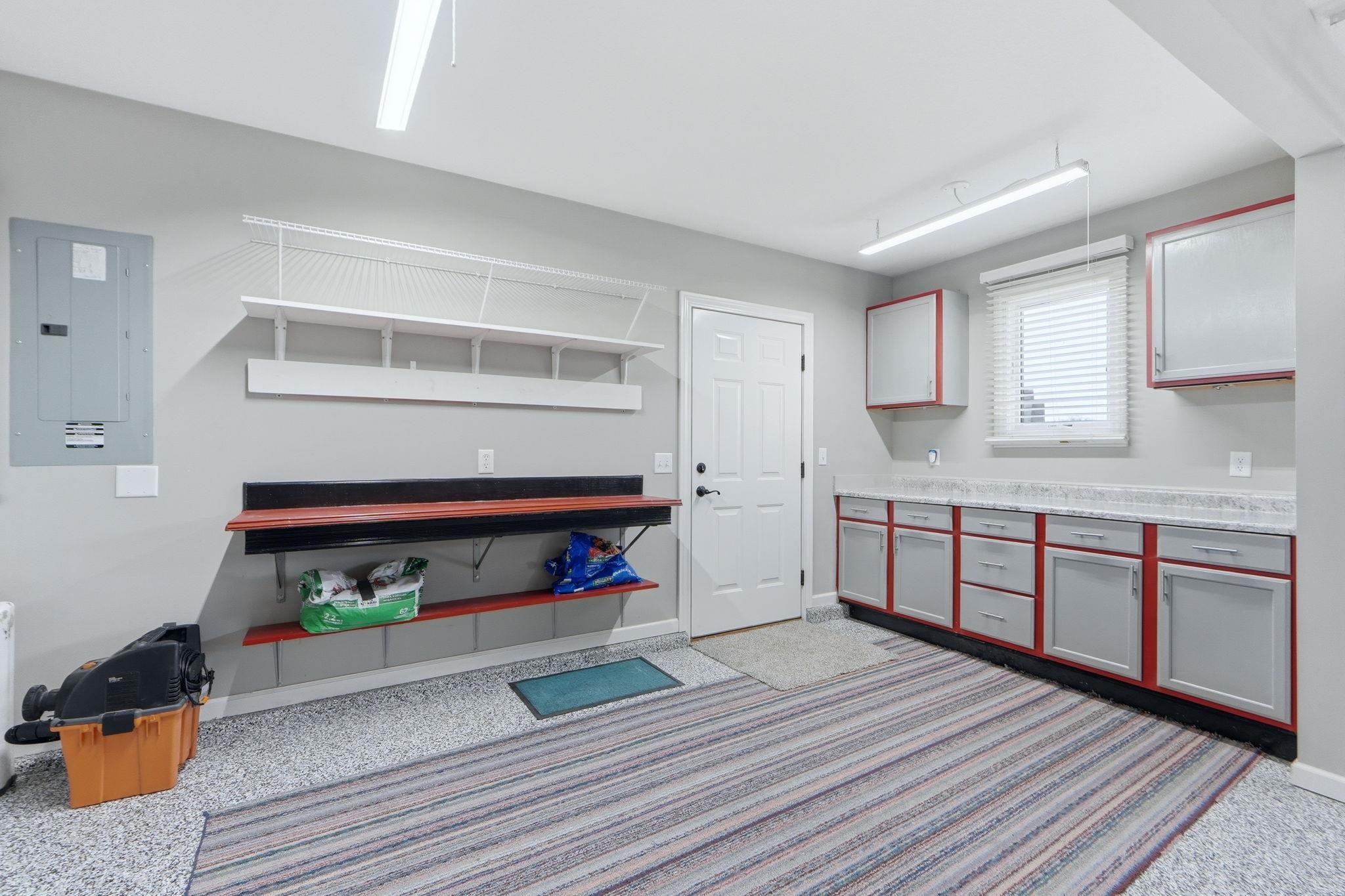 Kitchen with electric panel, light countertops, and light carpet