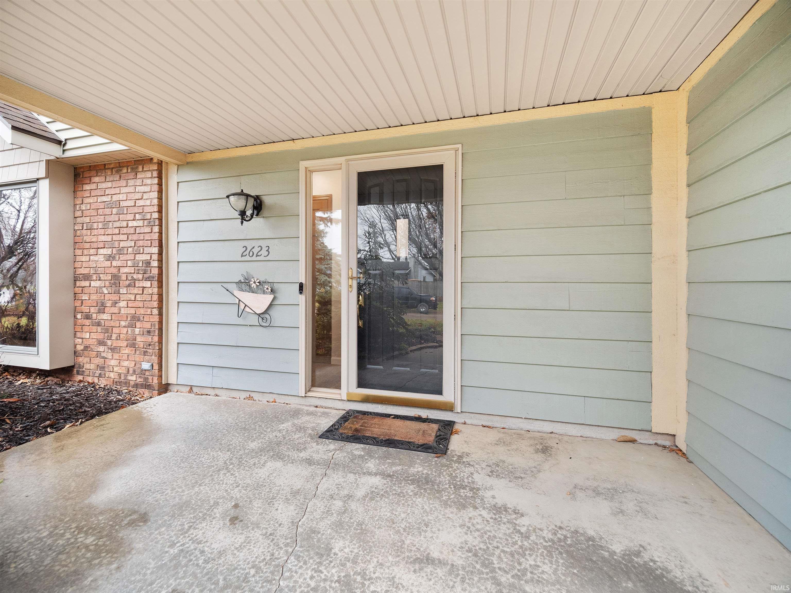 Doorway to property featuring brick siding