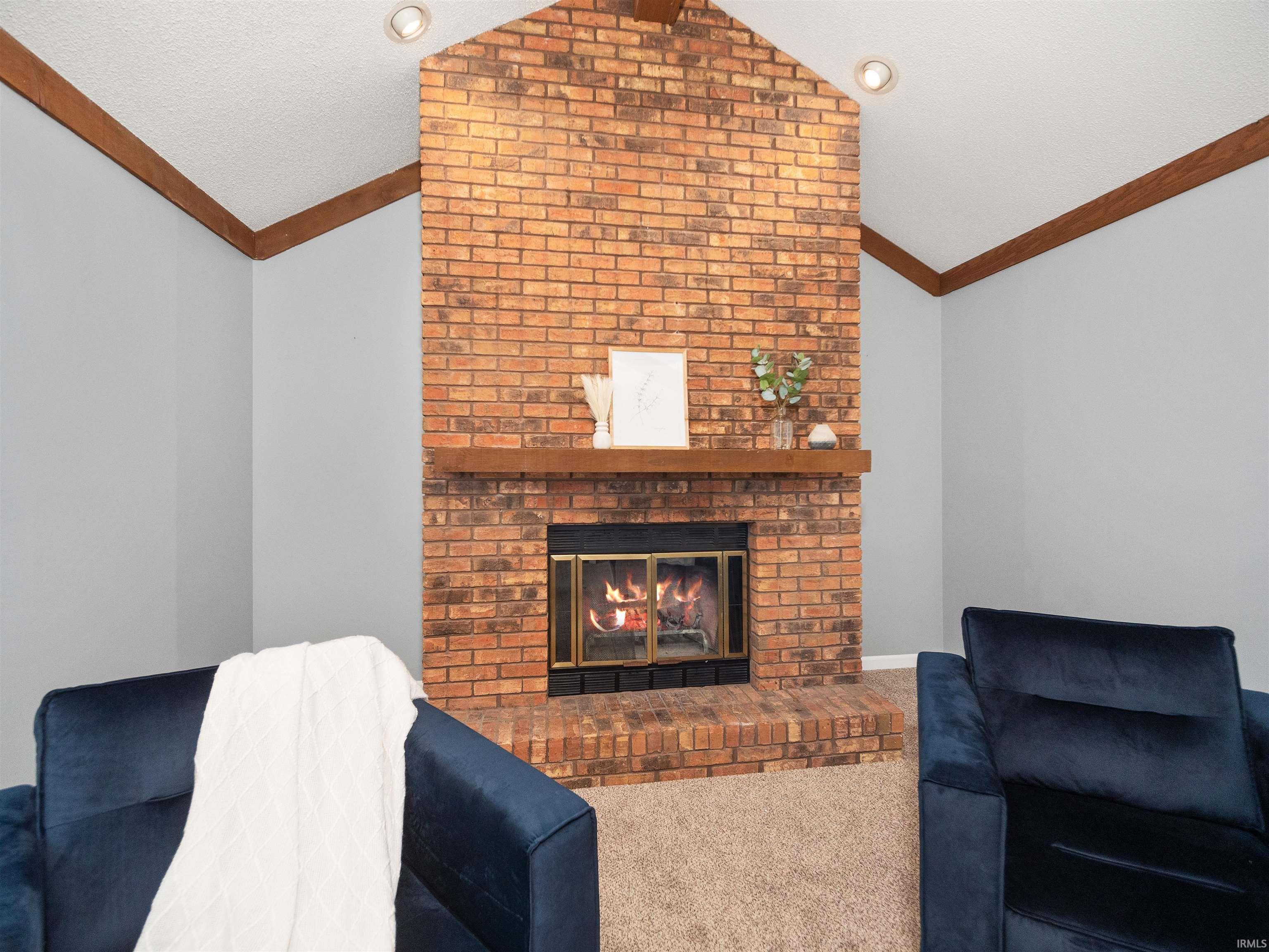 Living area with a fireplace and carpet flooring