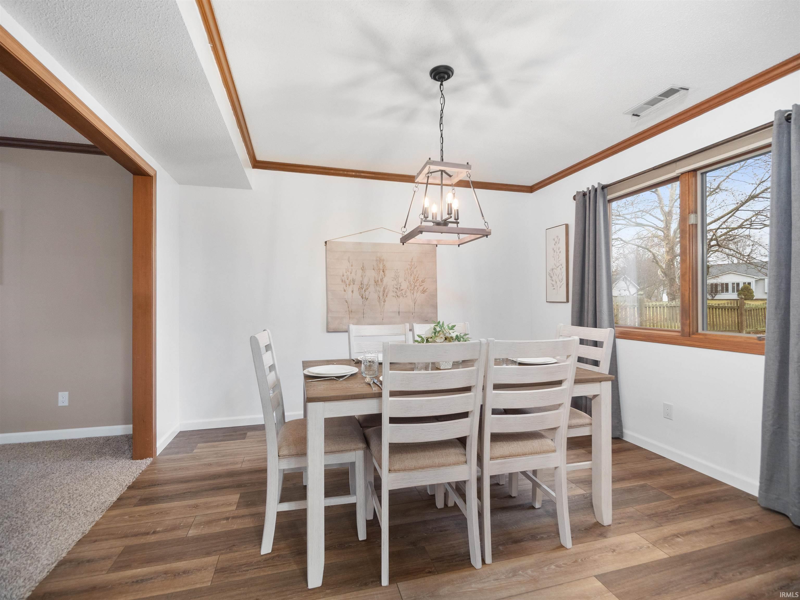 Dining area with wood finished floors and ornamental molding