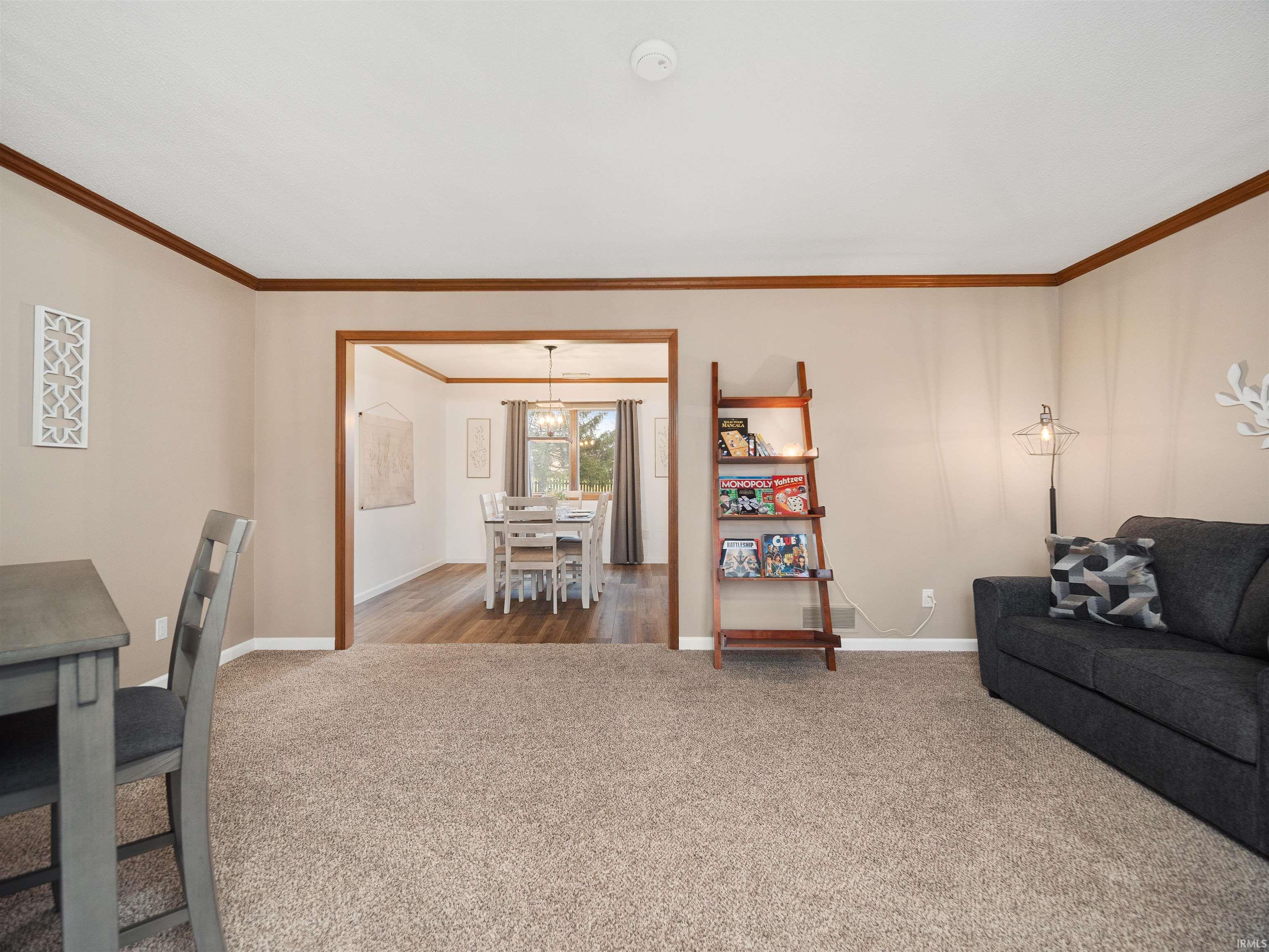 Carpeted living room with ornamental molding