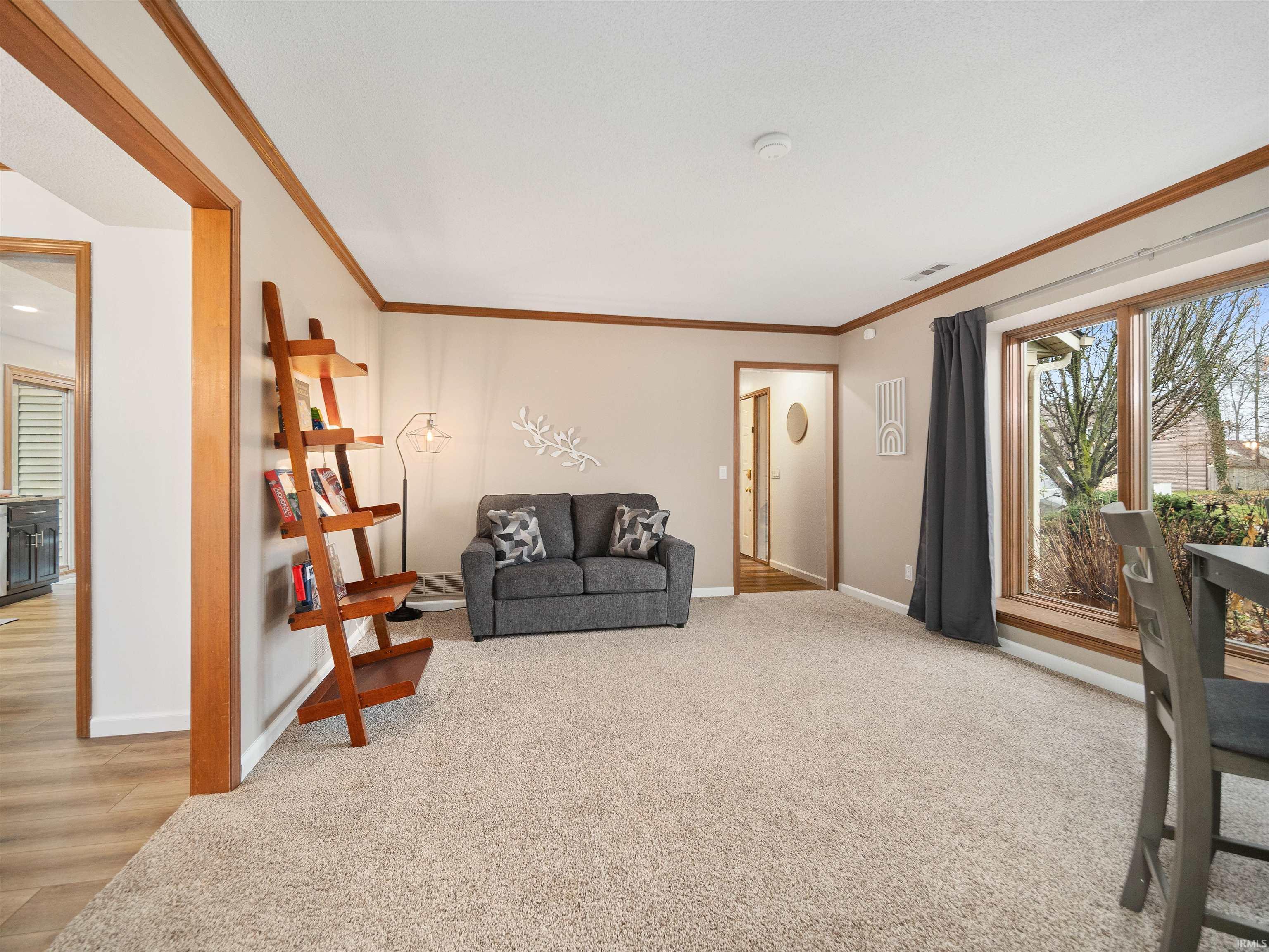 Sitting room featuring crown molding and light carpet