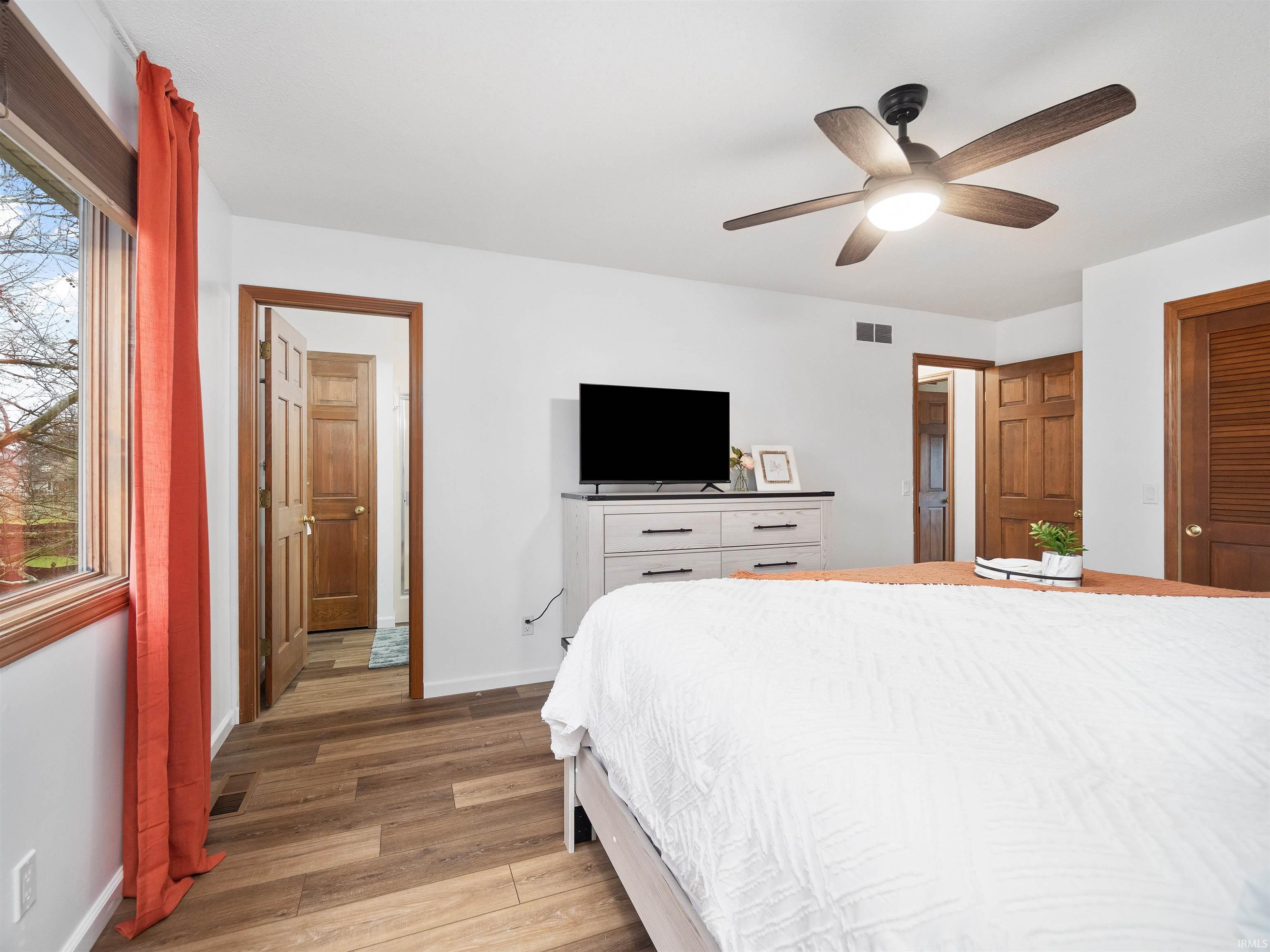 Bedroom with light wood-style floors, a ceiling fan, and a closet