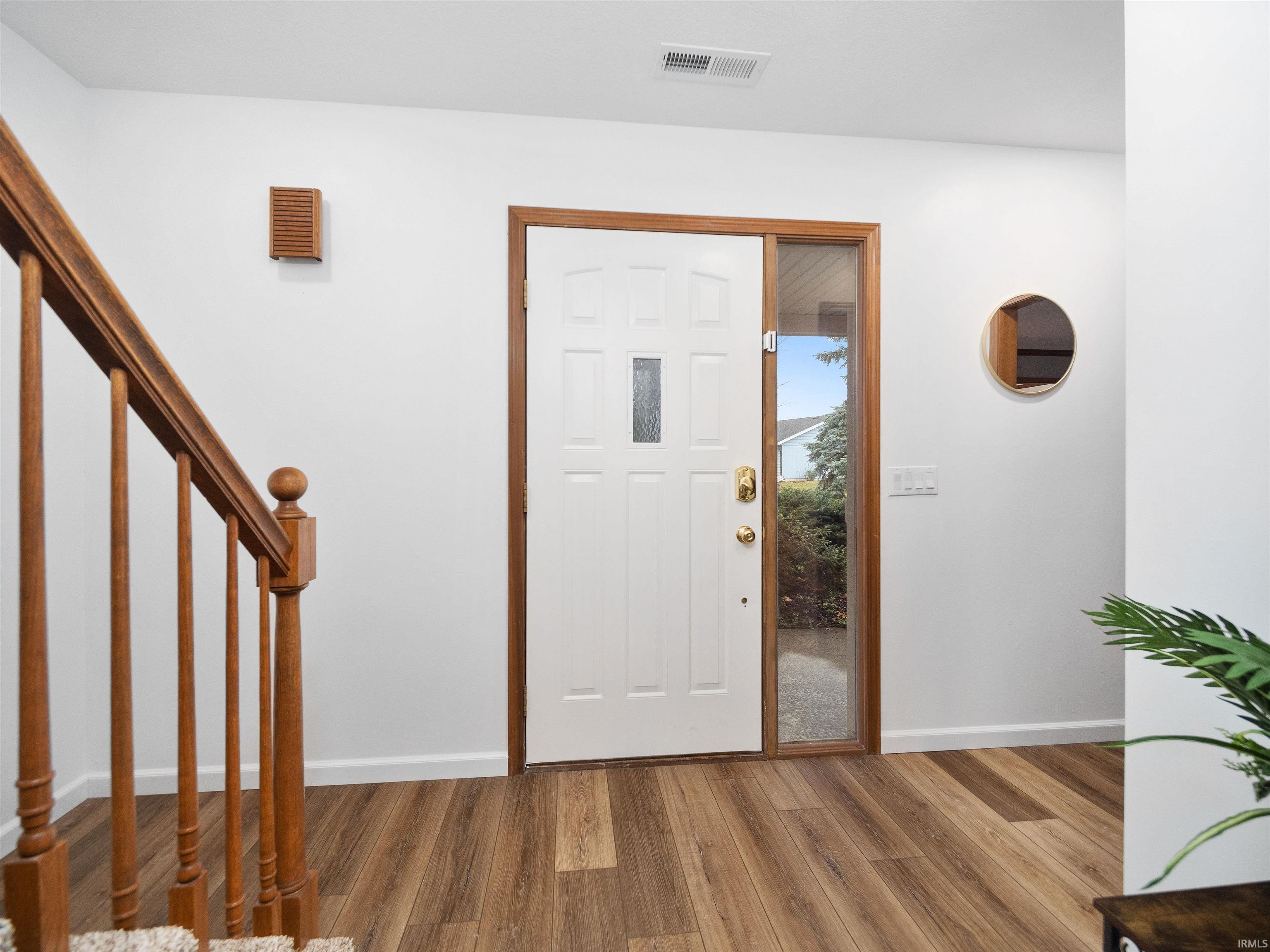 Foyer featuring wood finished floors and stairway
