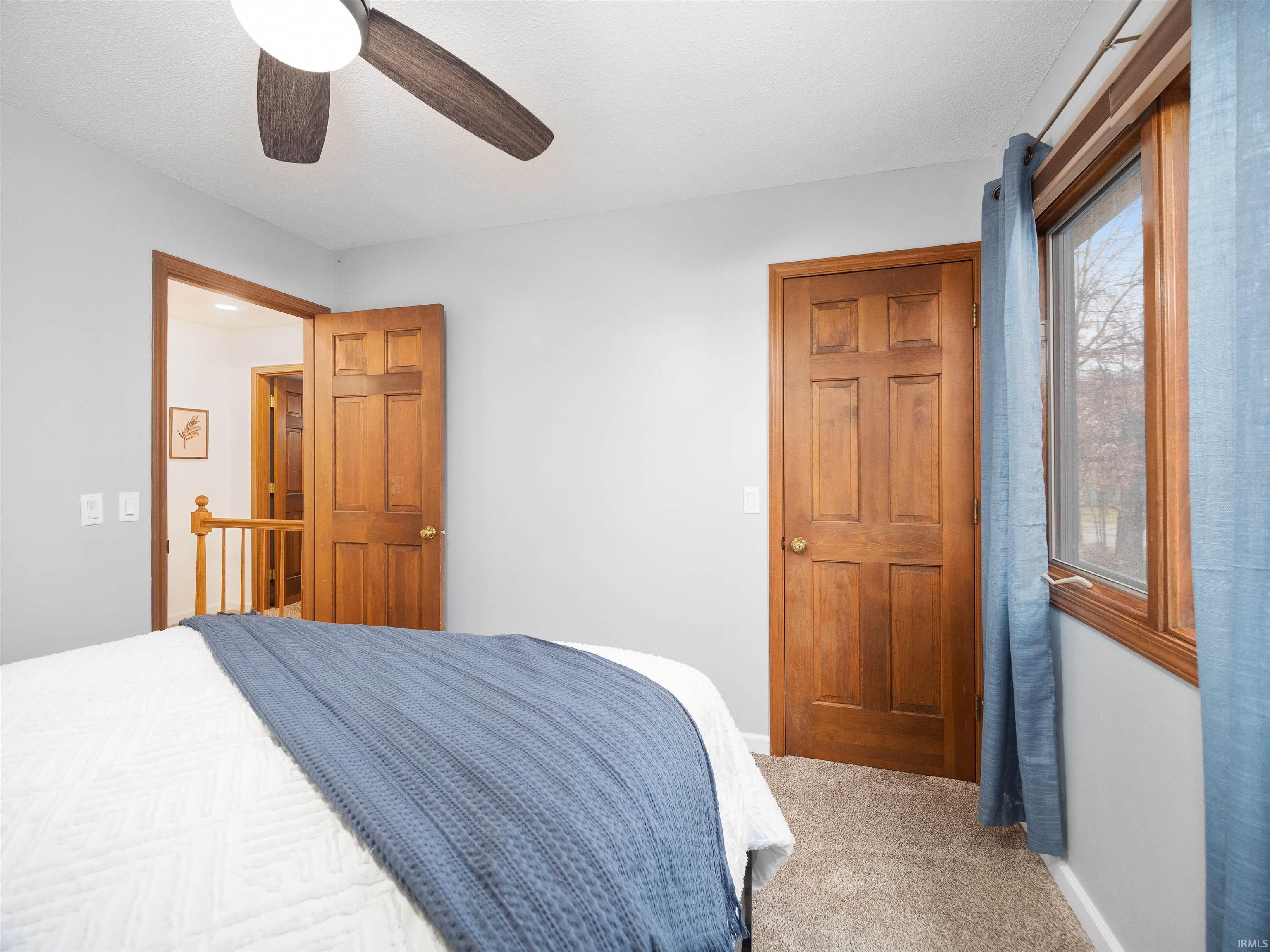Bedroom with light carpet and a ceiling fan