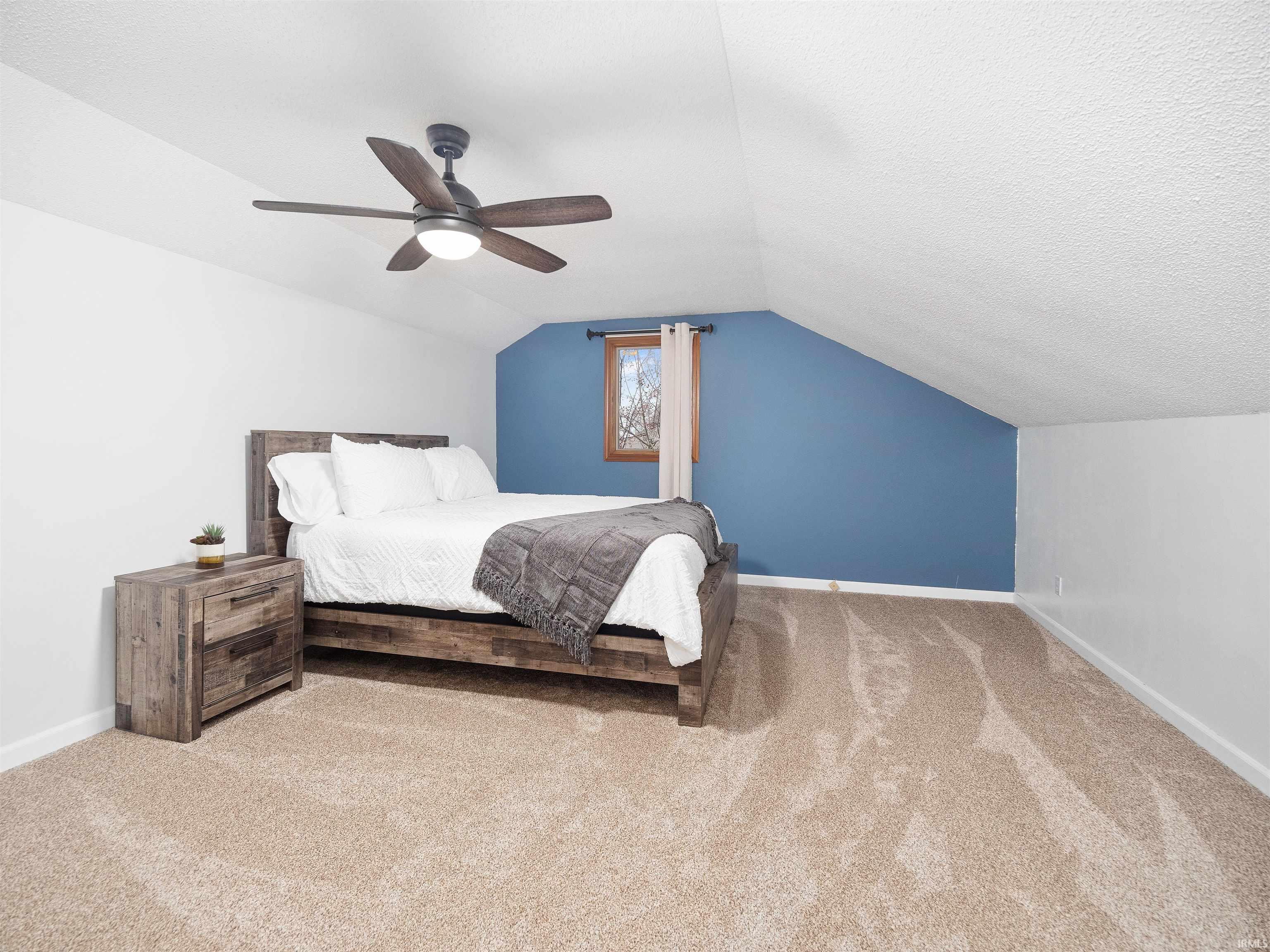 Bedroom featuring light colored carpet, a ceiling fan, and a textured ceiling