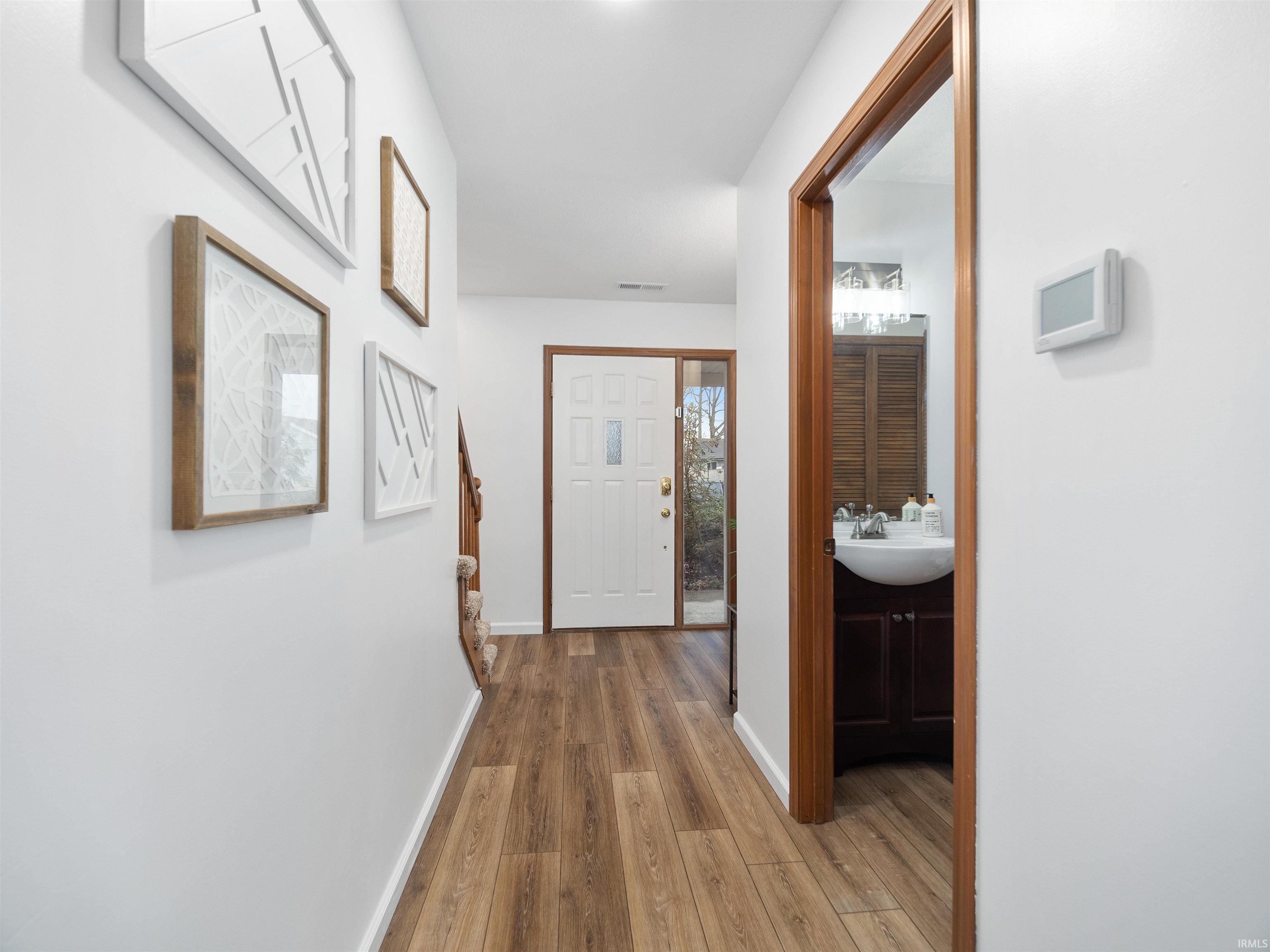 Hall featuring wood finished floors and baseboards