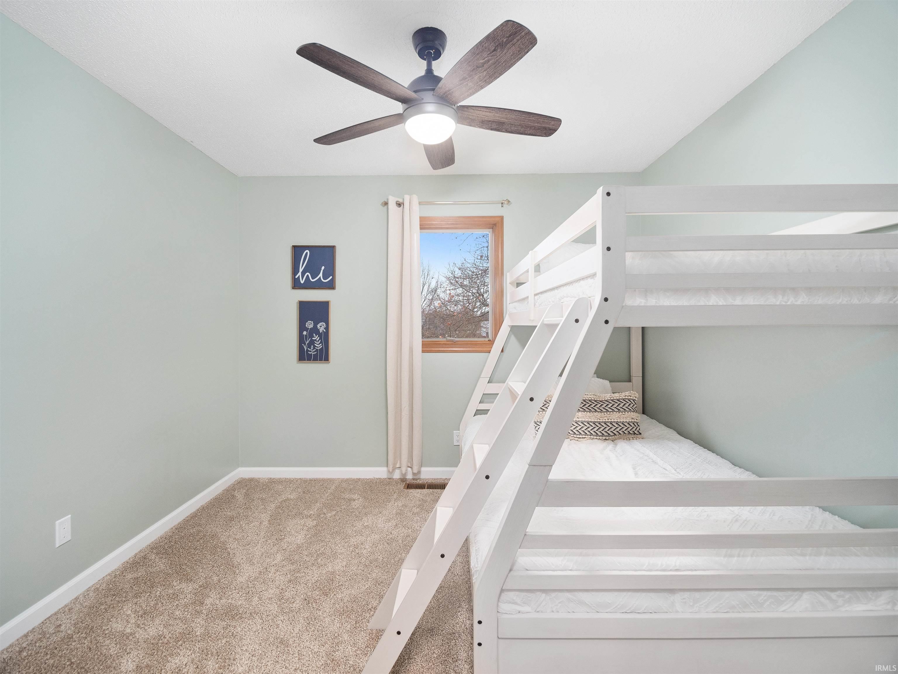 Unfurnished bedroom featuring light carpet and a ceiling fan