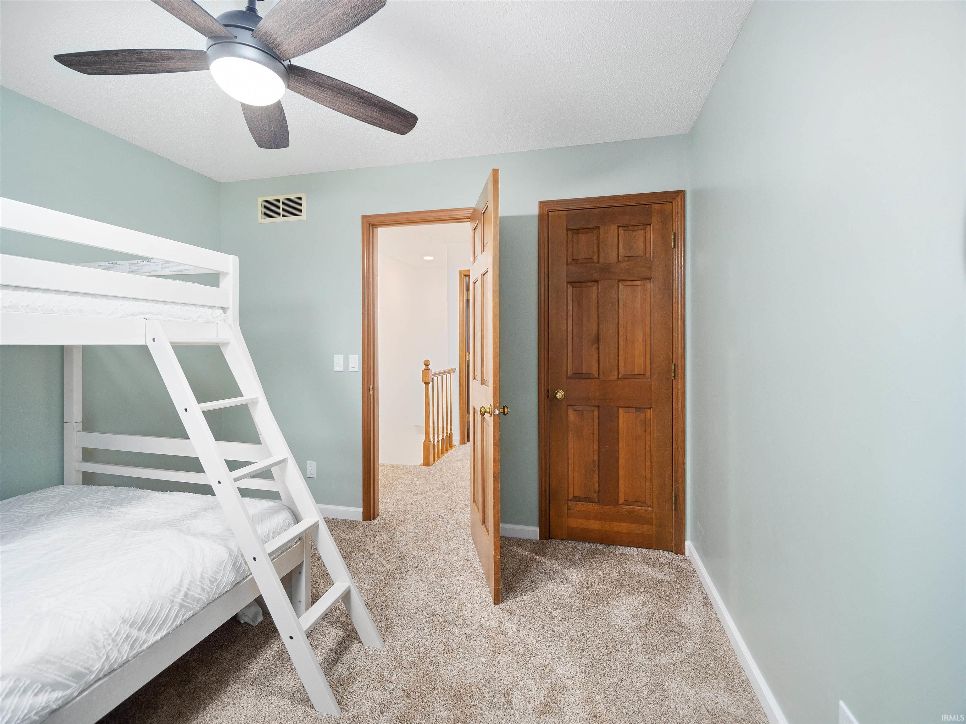 Bedroom featuring light colored carpet and a ceiling fan