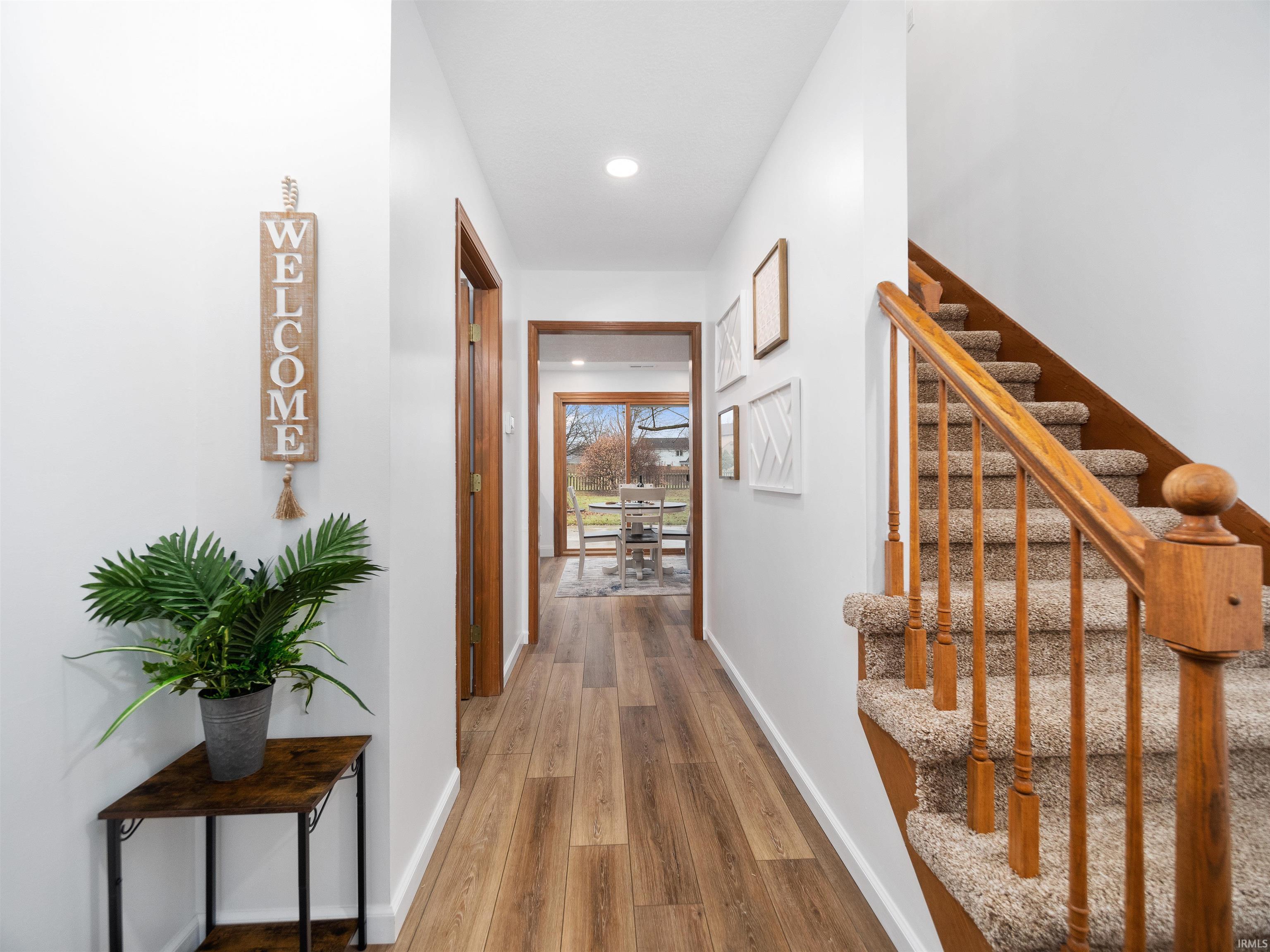 Hallway with light wood-style floors and recessed lighting