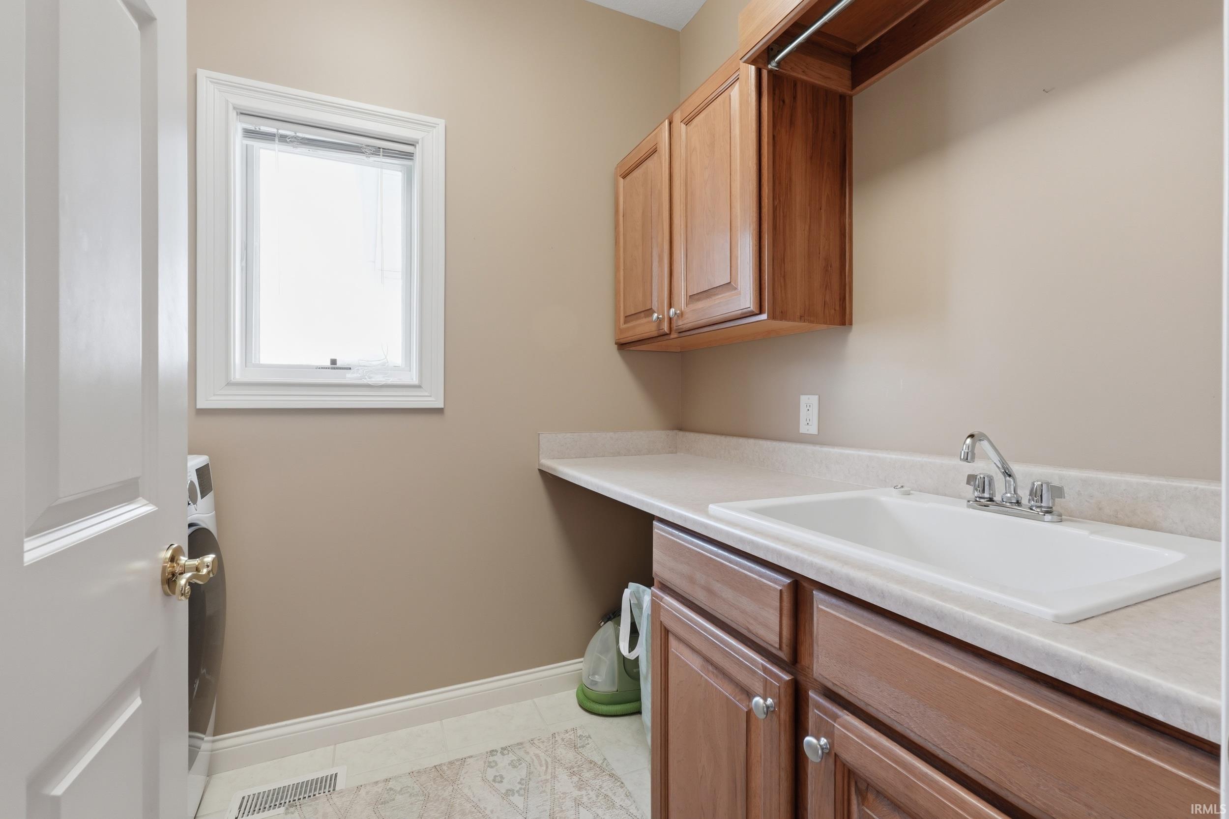 Laundry room with washer / clothes dryer and light tile patterned flooring