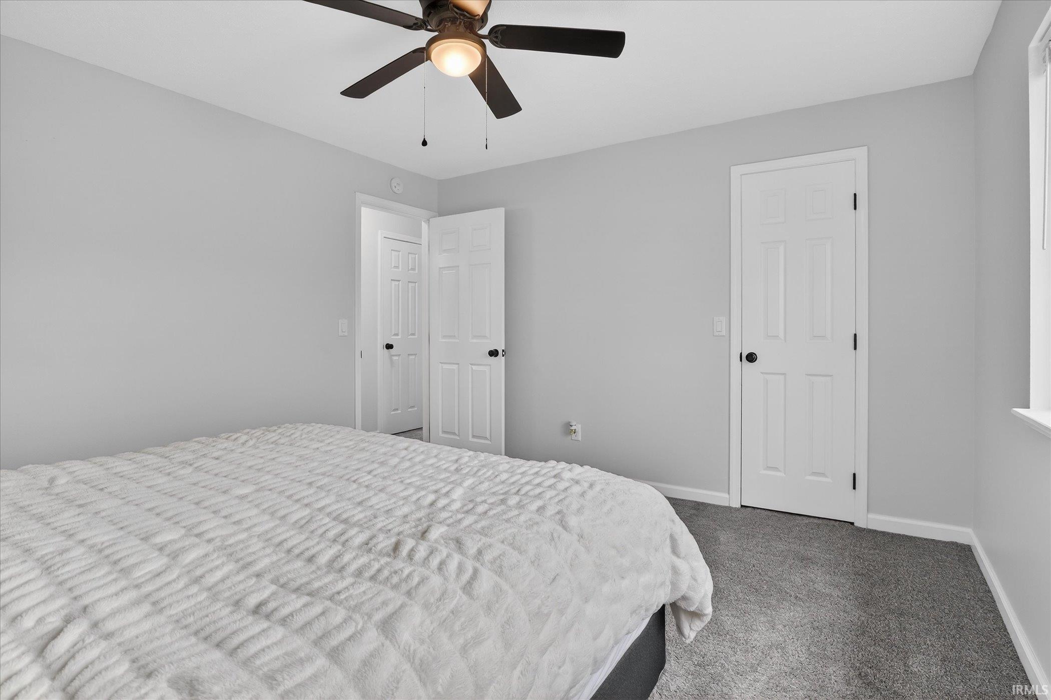 Bedroom with dark carpet and ceiling fan