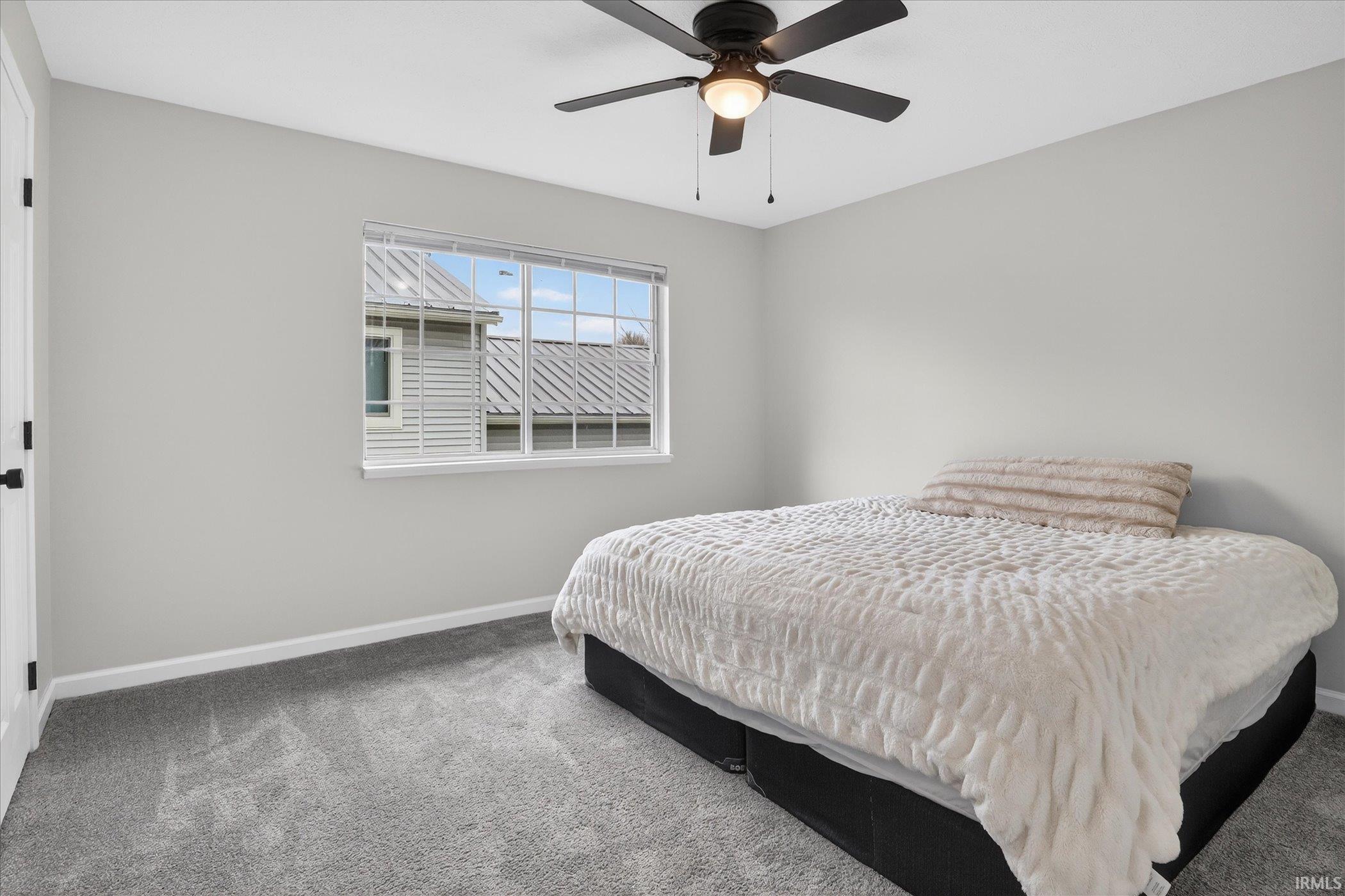 Carpeted bedroom with baseboards and ceiling fan