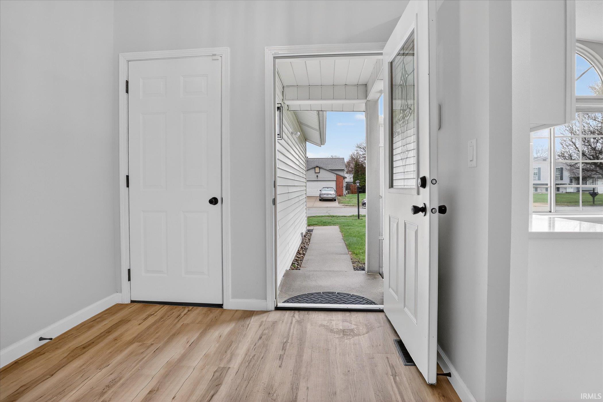 Entrance foyer with light wood-type flooring and baseboards