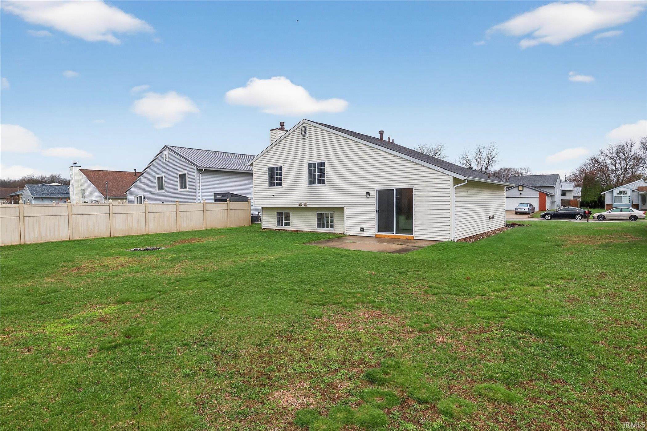 Back of house featuring a patio area, a yard, and a residential view