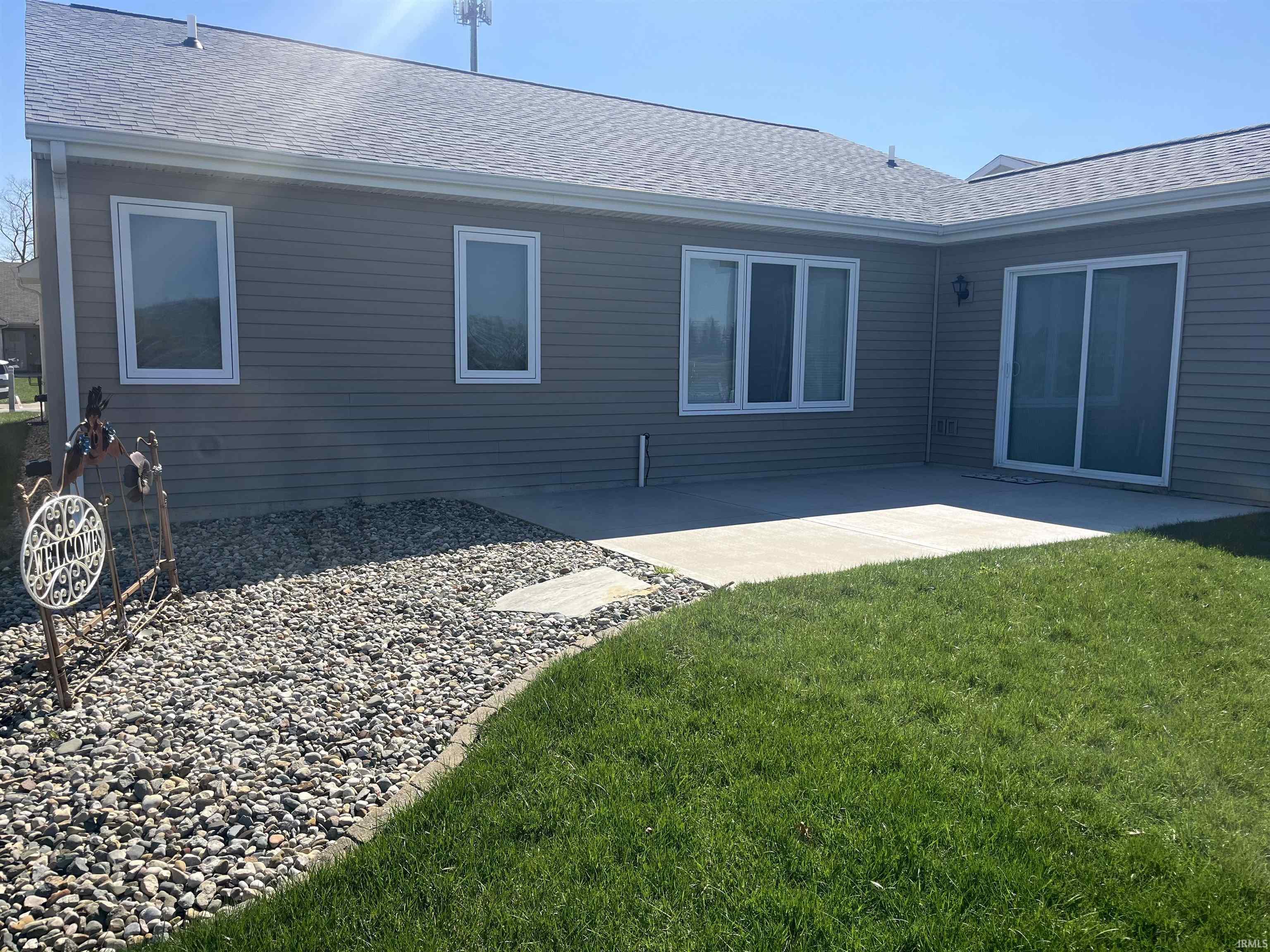 Back of property featuring roof with shingles, a yard, and a patio area