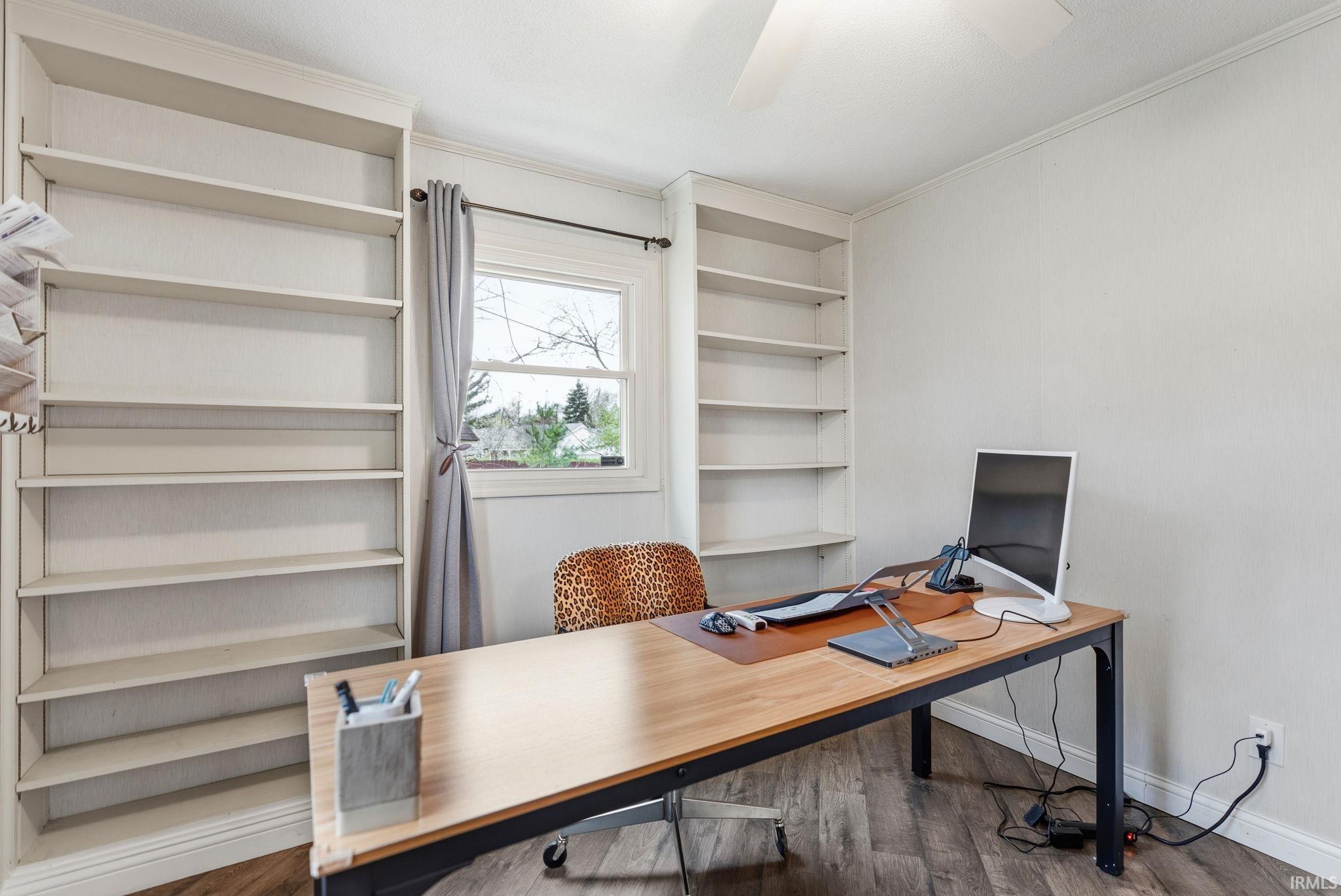 Office area with wood finished floors, ornamental molding, ceiling fan, and built in shelves