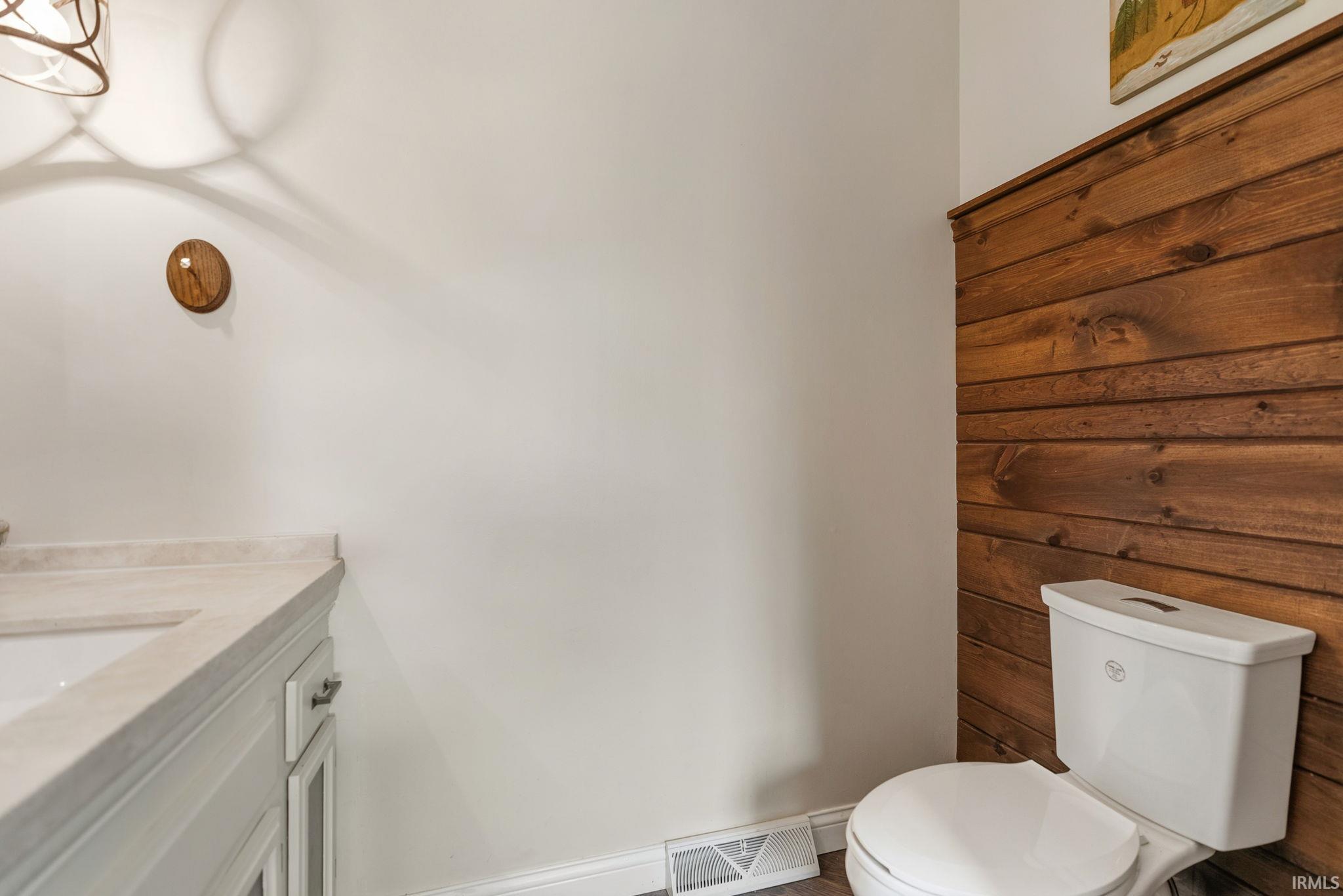 Half bath featuring vanity and baseboards