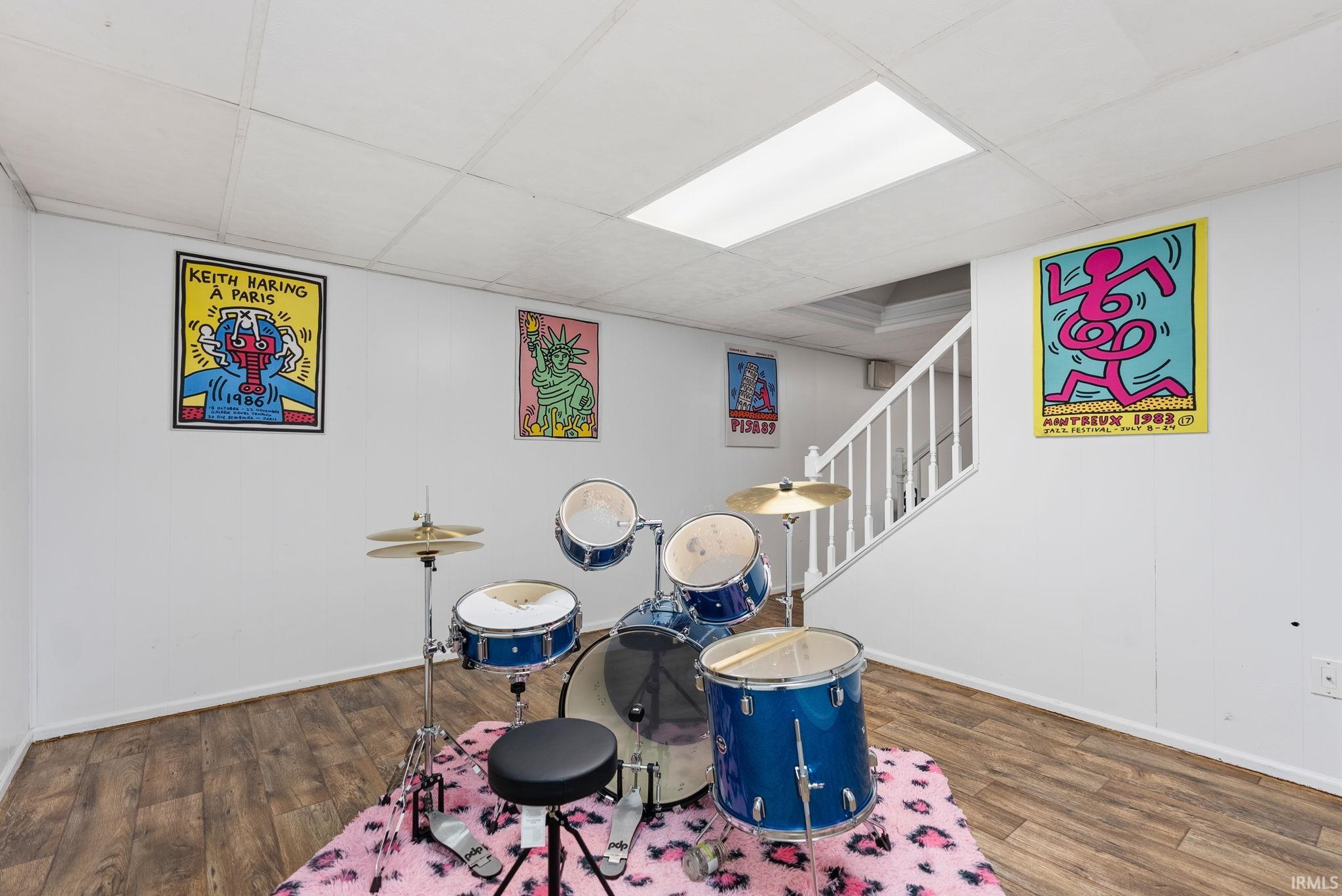 Game room with a paneled ceiling and dark wood-style flooring