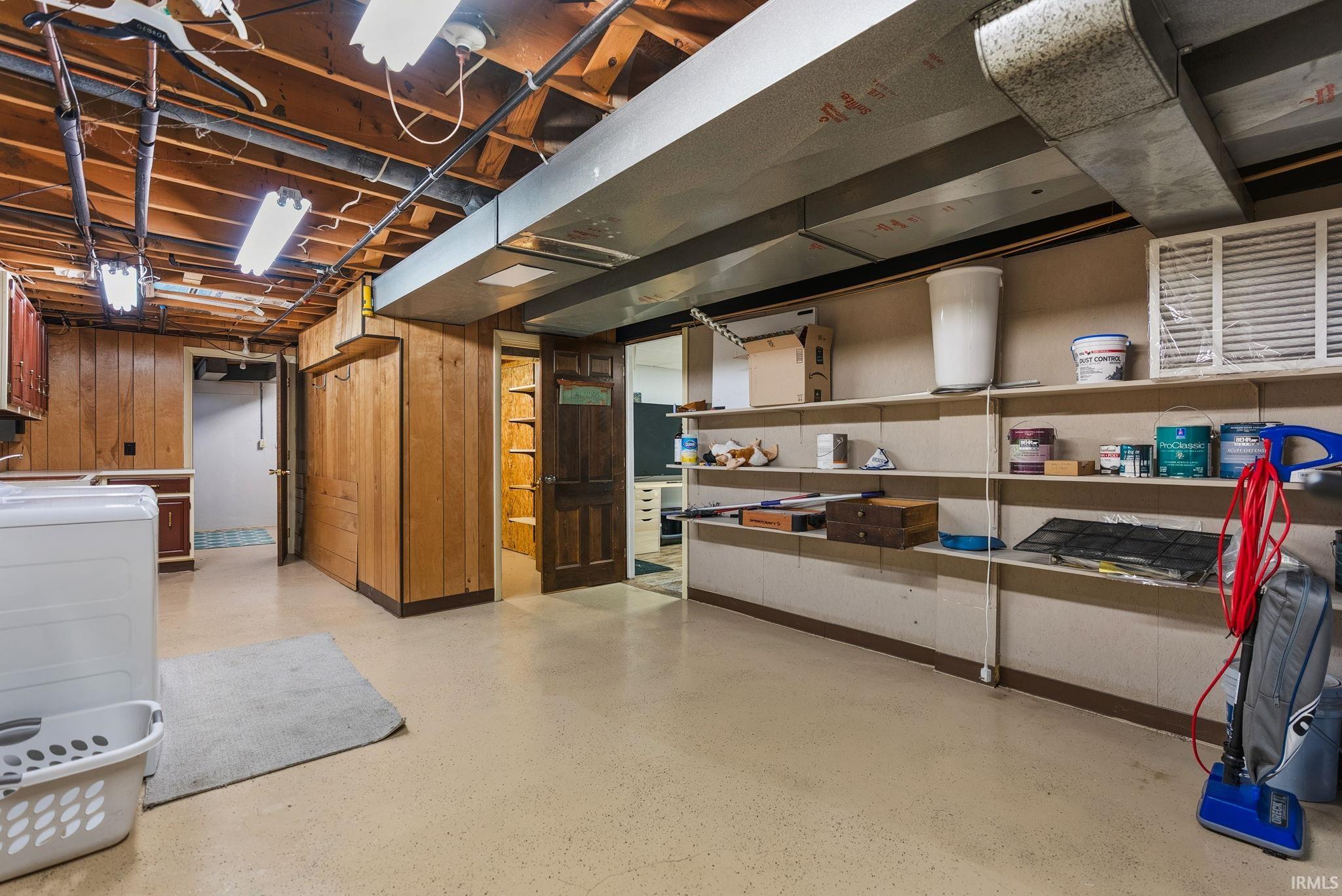 Unfinished basement featuring wooden walls
