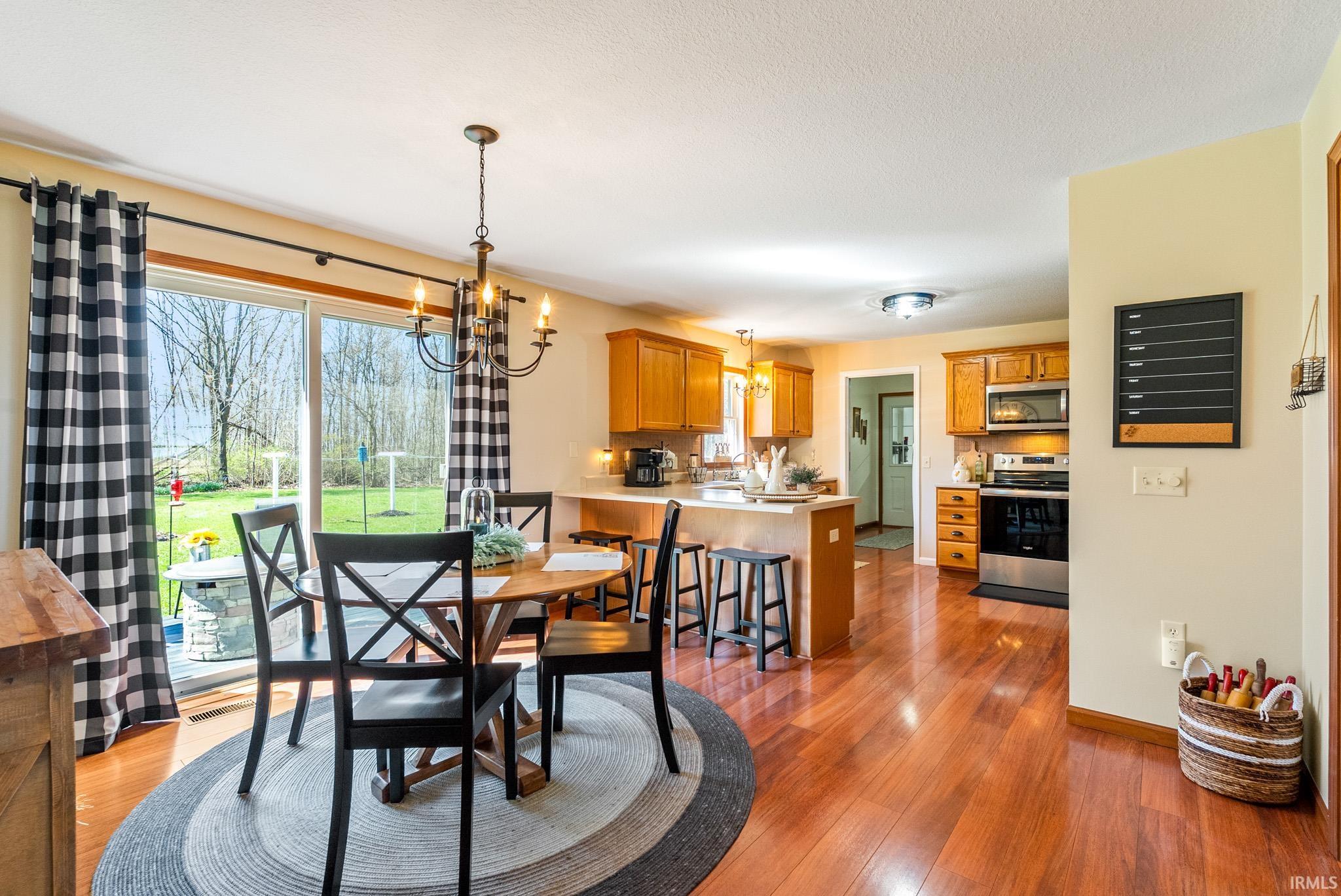 Dining area with suspended lighting, light wood-type flooring, and plenty of natural light