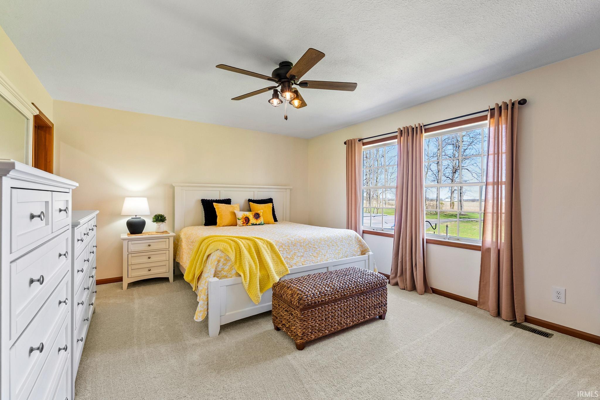 Bedroom with a ceiling fan and light carpet