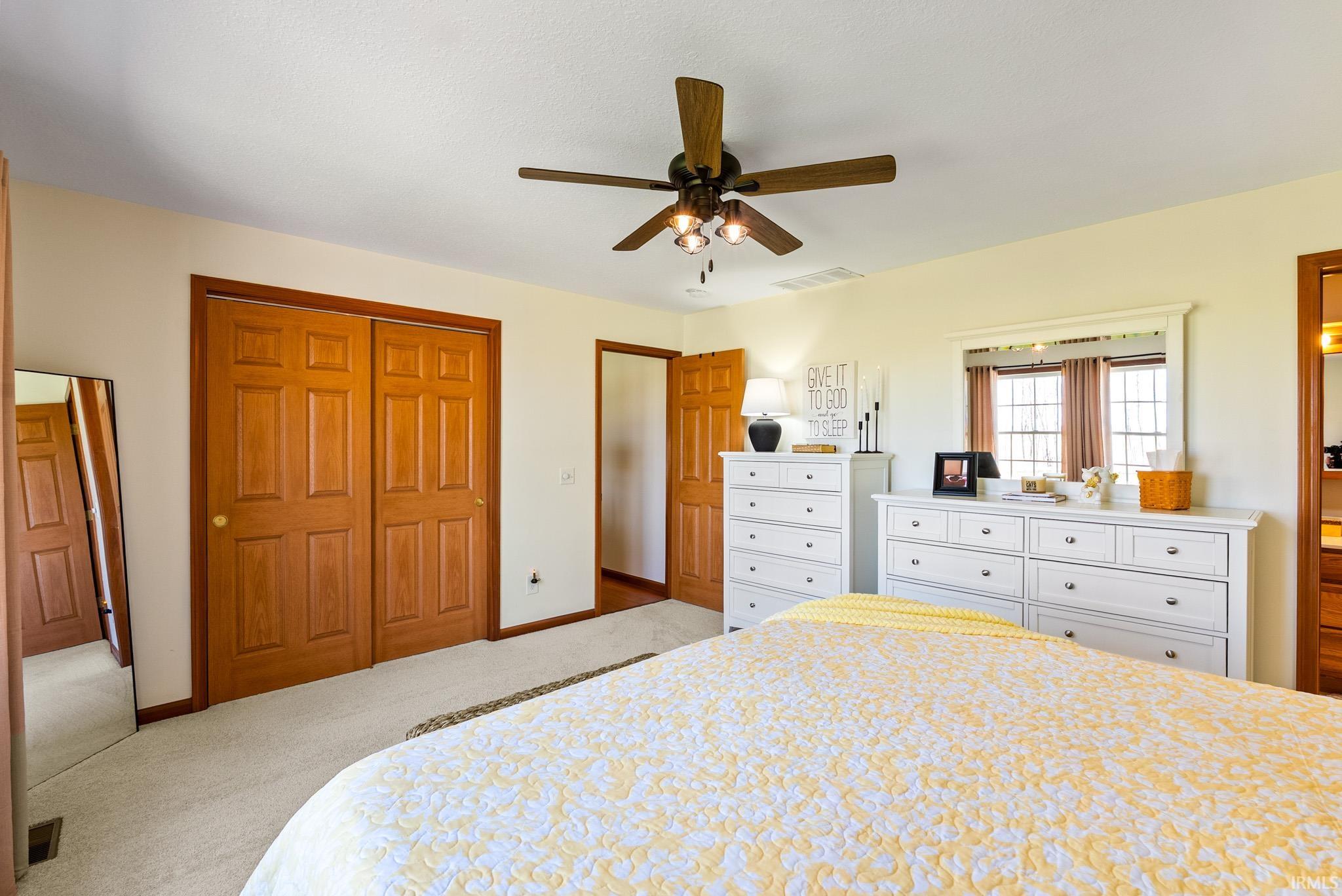 Bedroom featuring a closet, ceiling fan, and carpet flooring