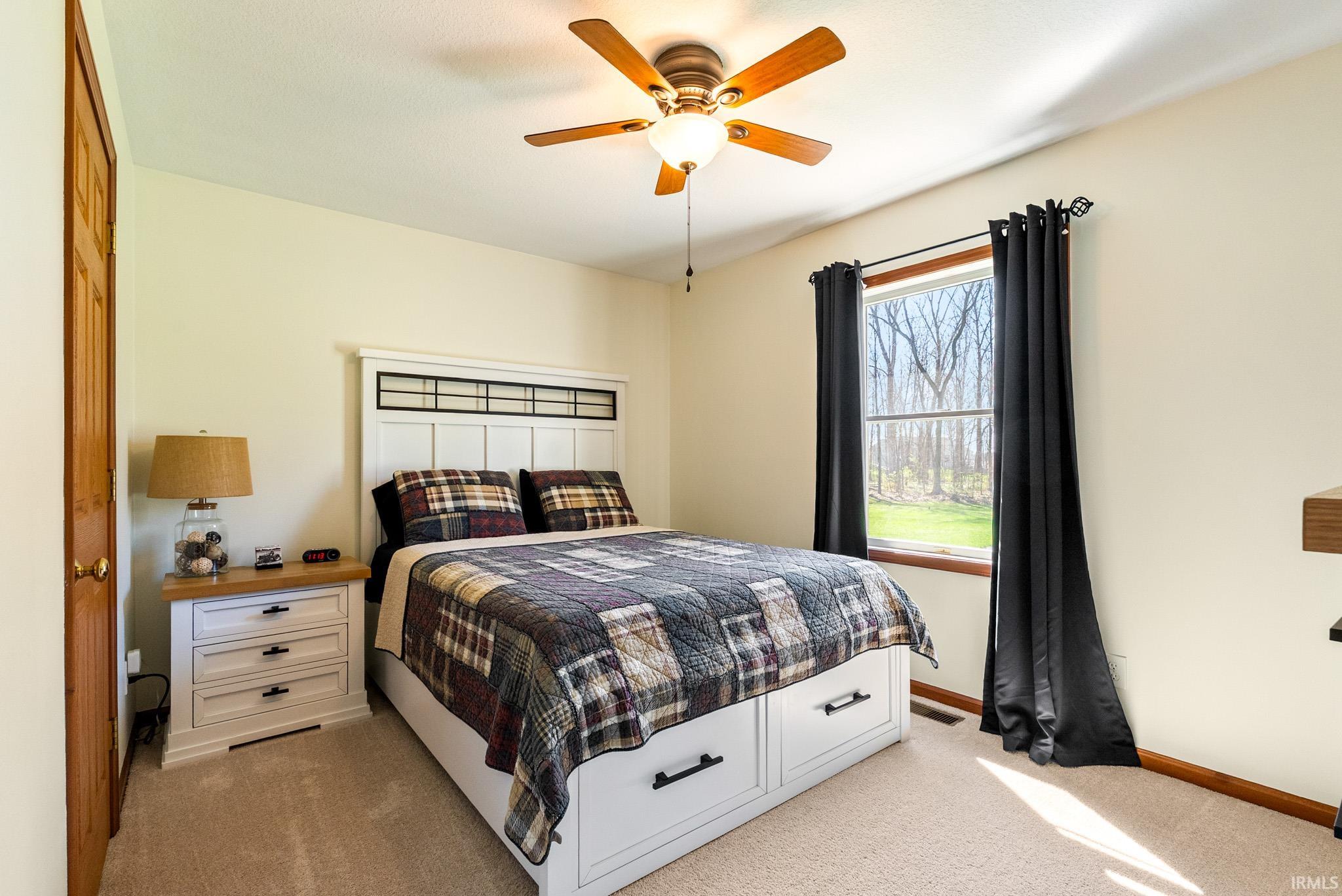 Bedroom with light carpet and ceiling fan