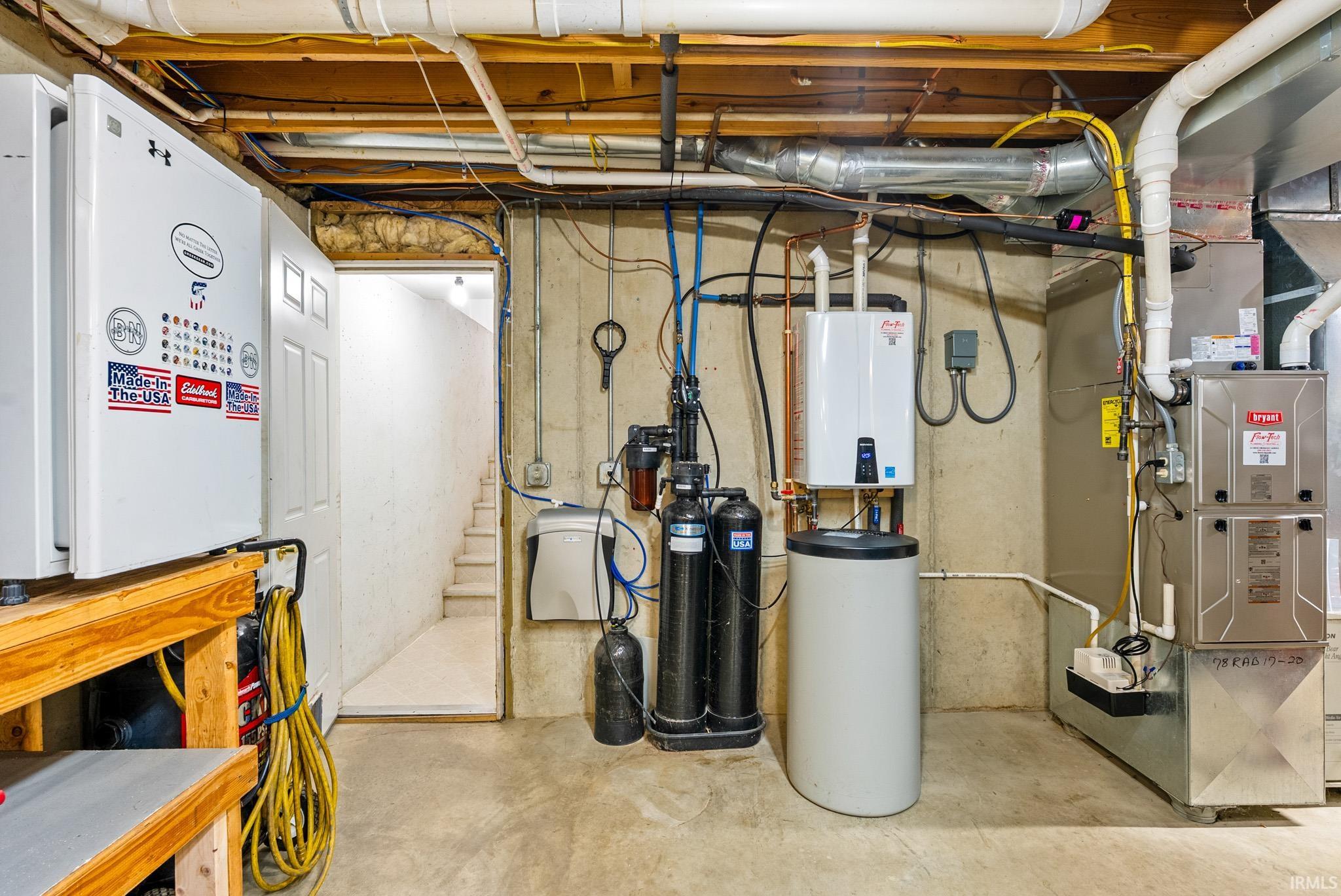 Utility room featuring heating unit and tankless water heater