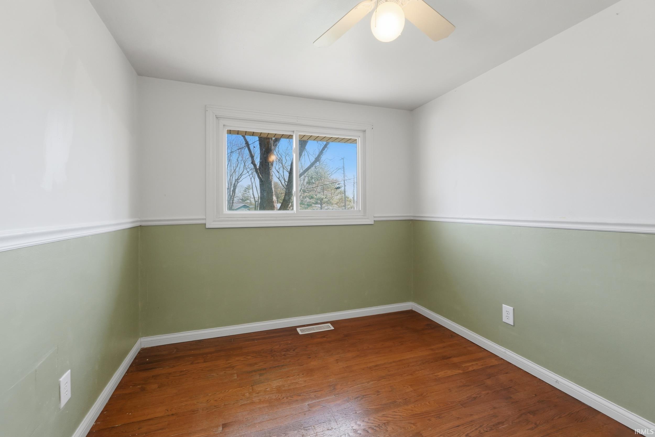 Unfurnished room with ceiling fan and dark wood-type flooring