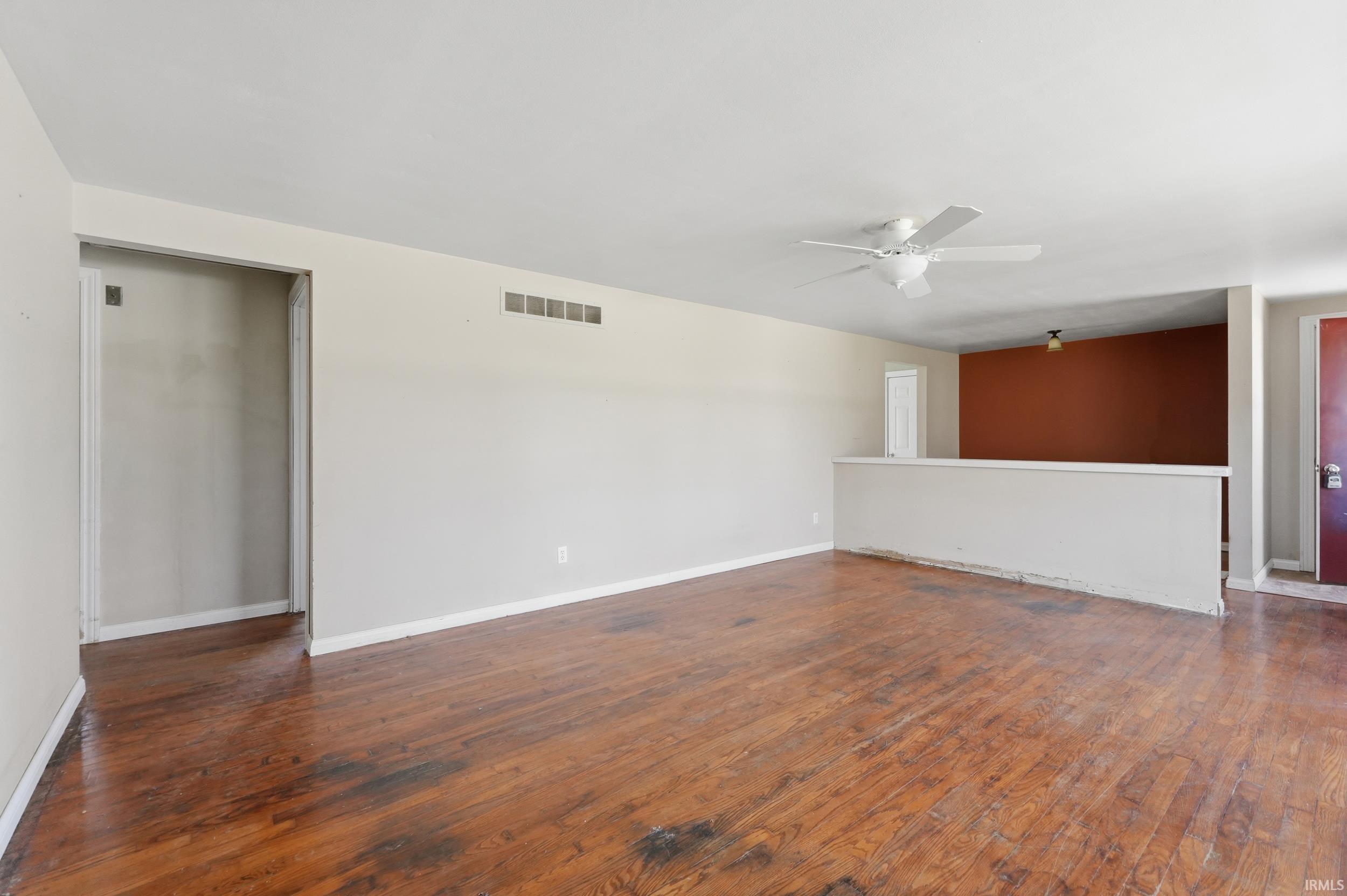 Unfurnished room featuring dark wood finished floors and a ceiling fan